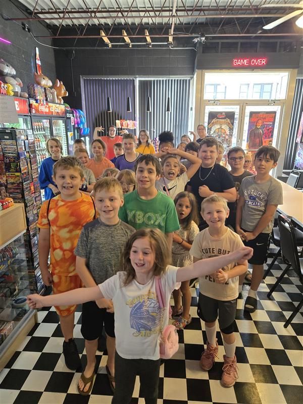 Club kids gather on a black-and-white checkered floor at the Pinball Museum.