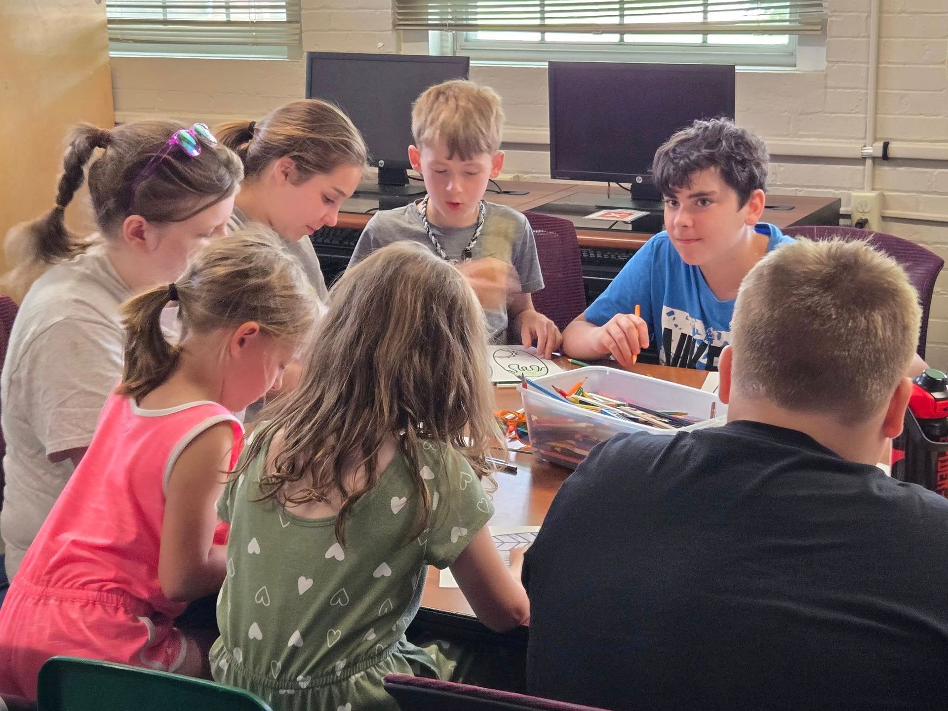 Club kids sitting at a table enjoying an arts actvity.