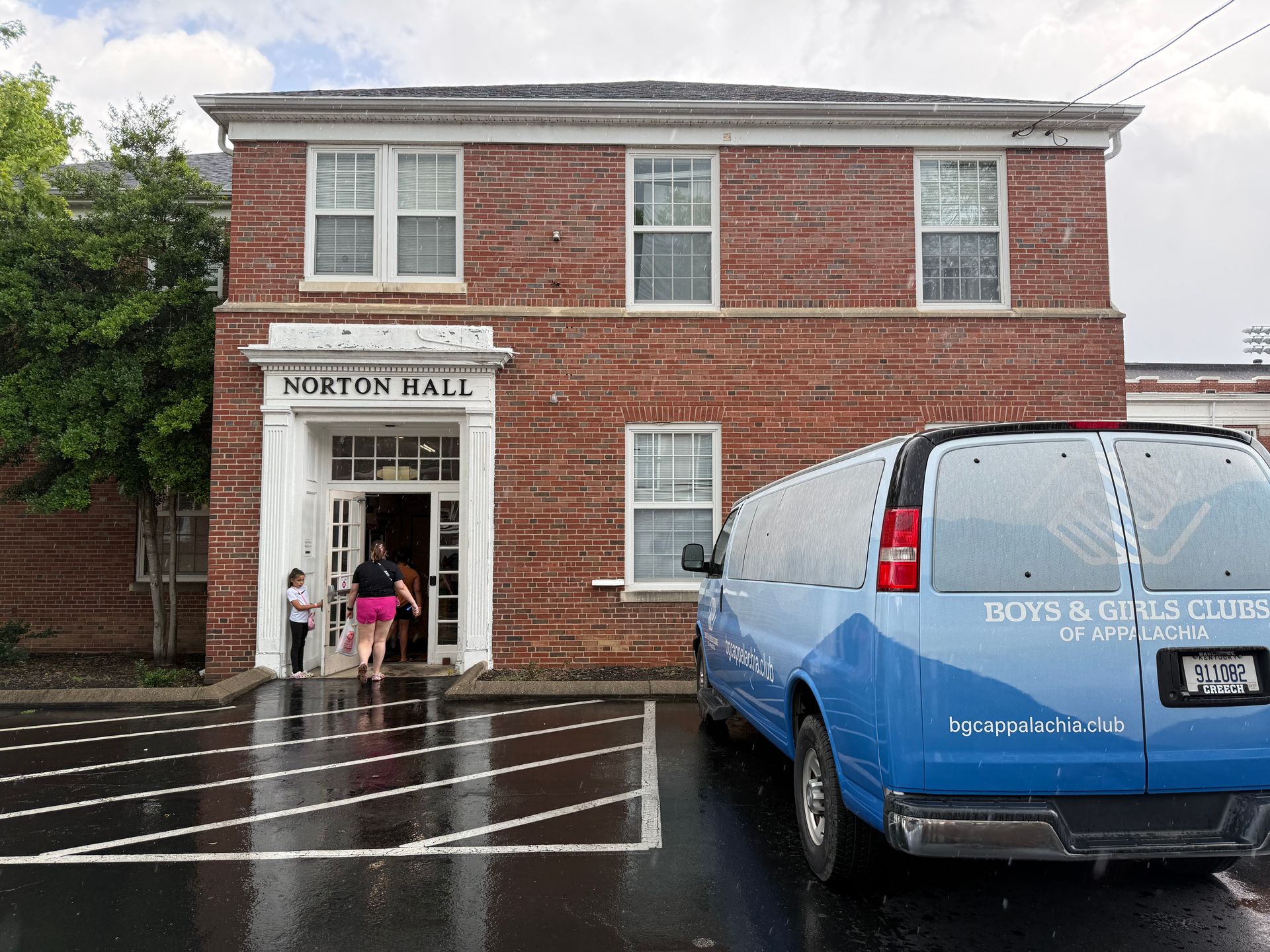 Children enter Norton Hall, a brick building with a van parked out front that reads Boys & Girls Clubs of Appalachia.