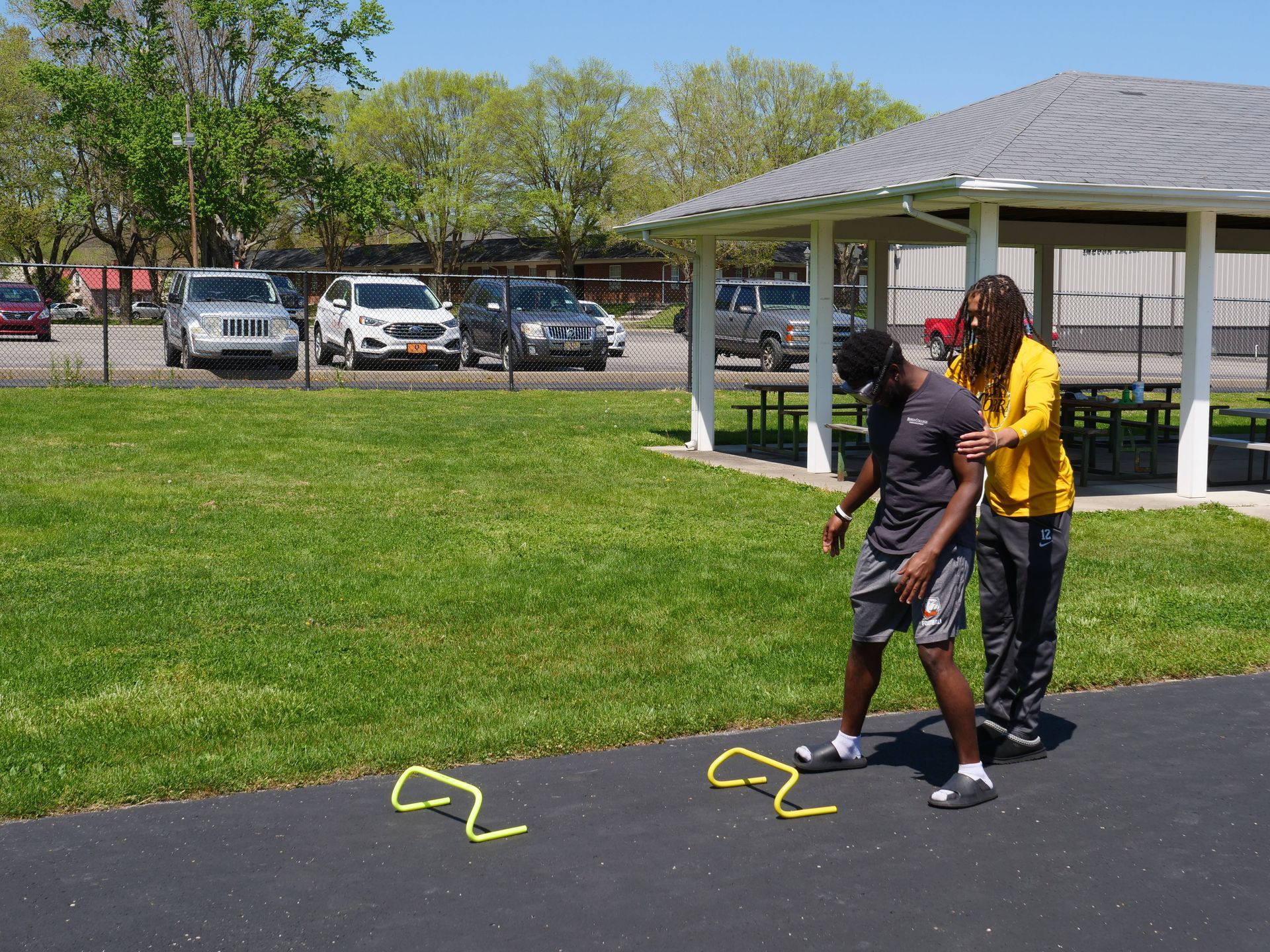 A student being directed to a small obstacle course while wearing drunk goggles.