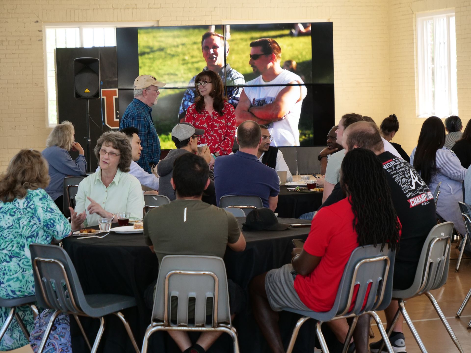 Retirement party attendees sitting around tables and chatting.