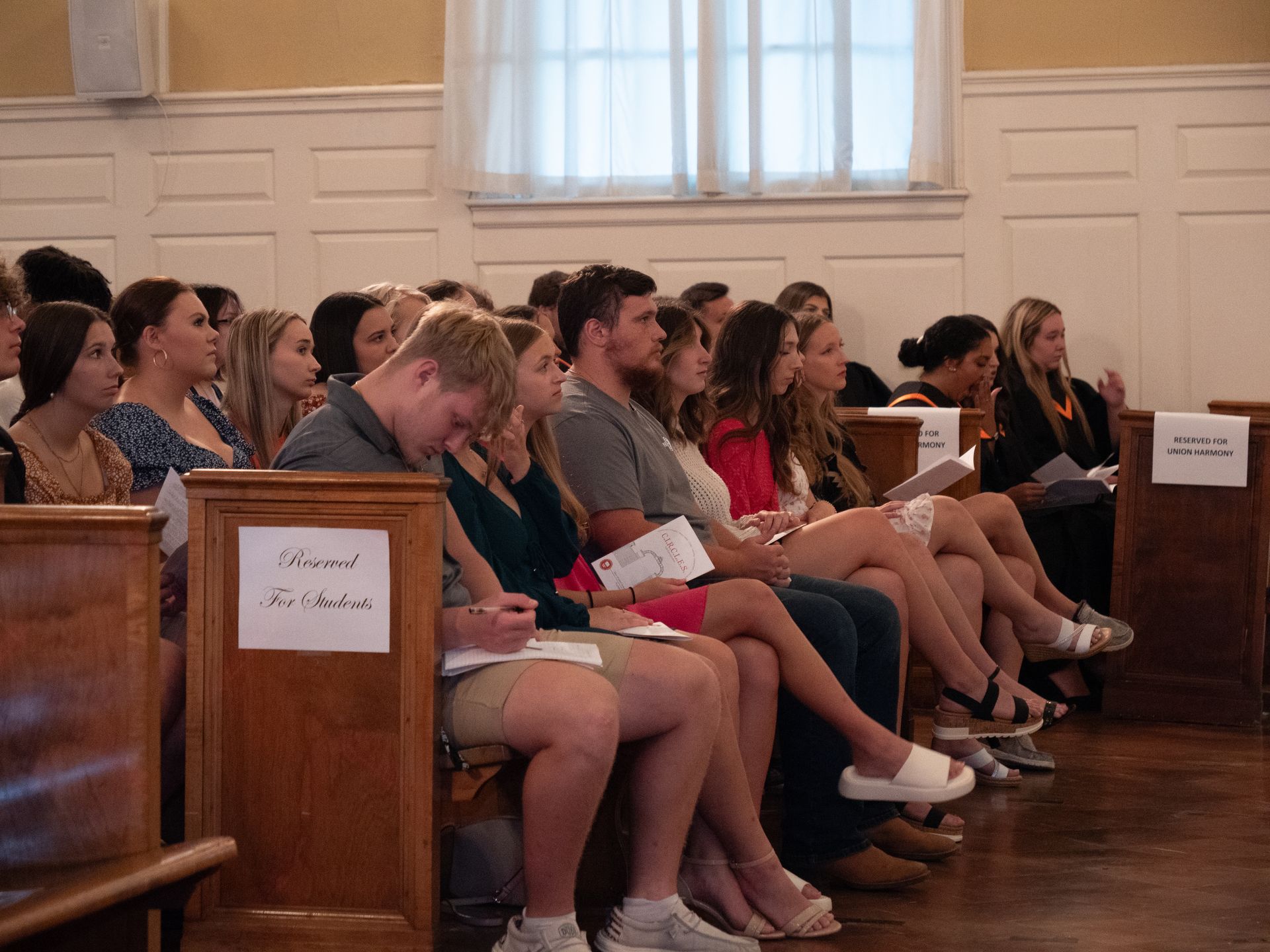 Freshman students sitting in a front pew of Conway Boatman Chapel.