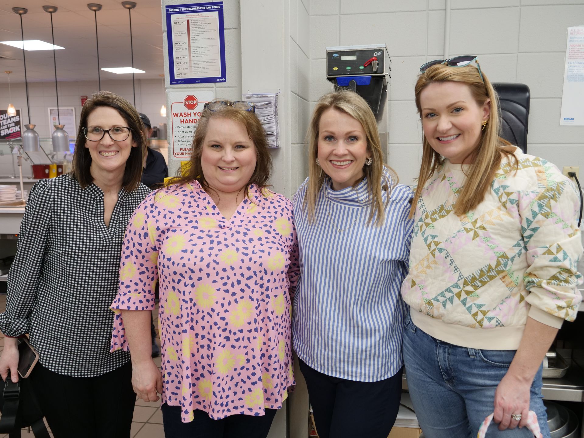 Four parent attendees smiling in Union's kitchen.