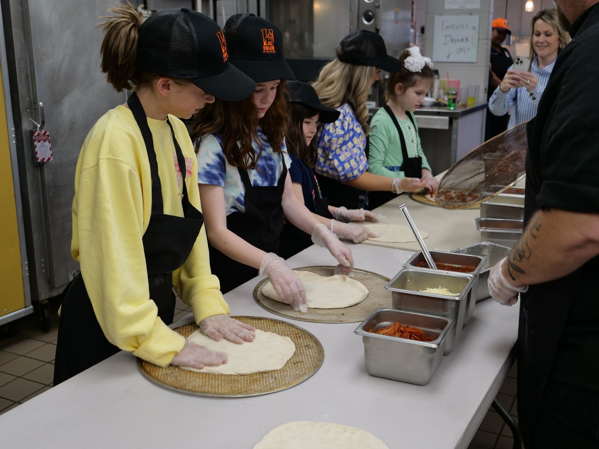 attendees make pizza alongside Union Dining staff