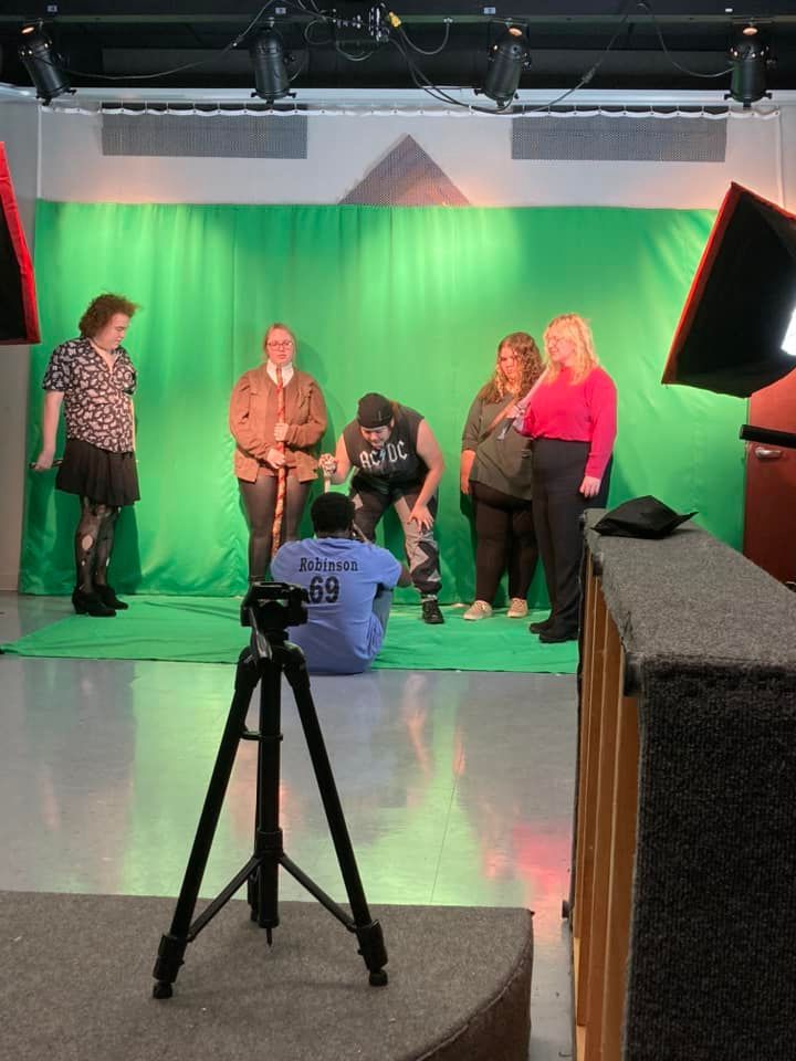 Actors gather around DeAaron Robinson as he creates special effects with a green screen.