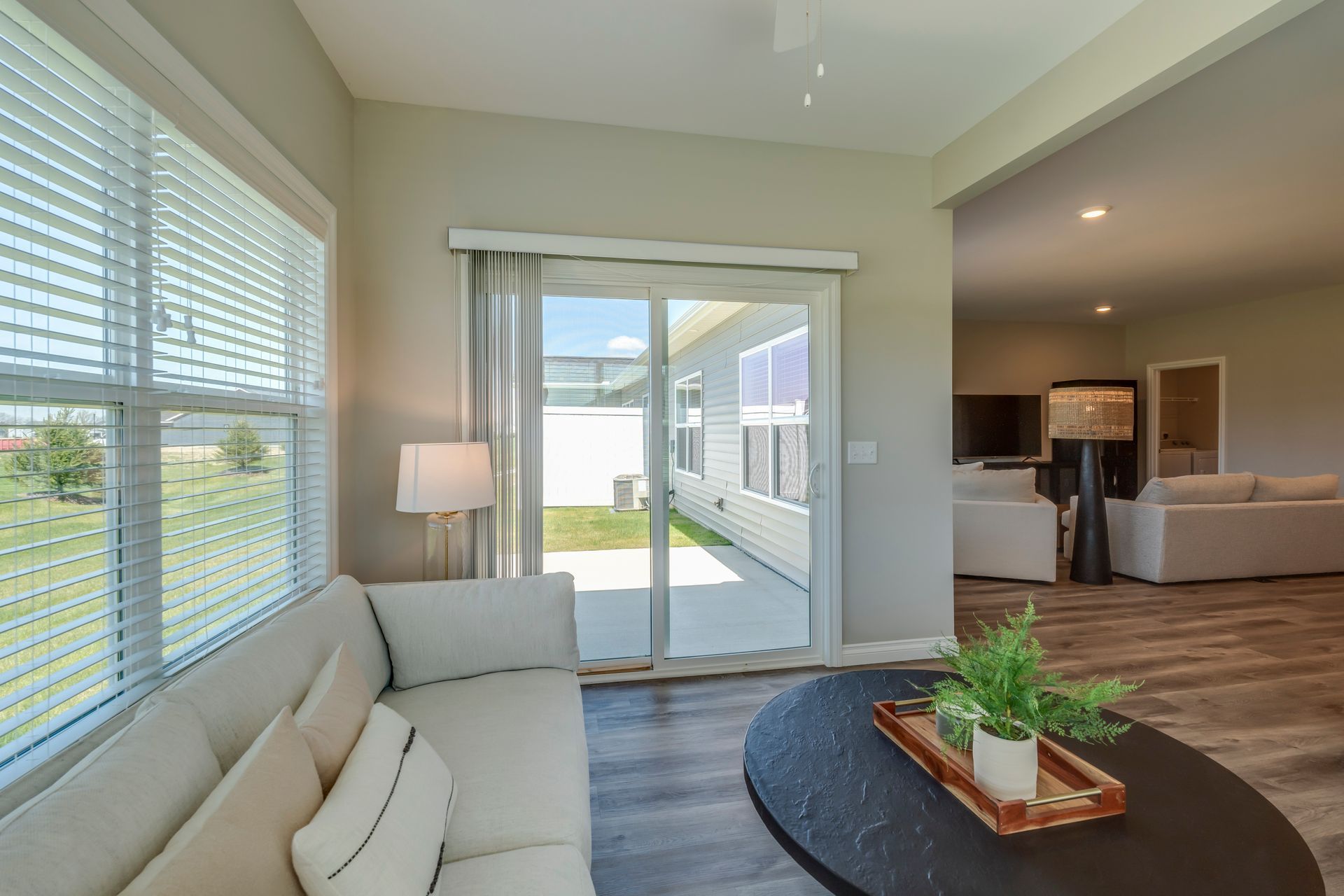 Living room with couch, coffee table, sliding glass door to patio, and windows.