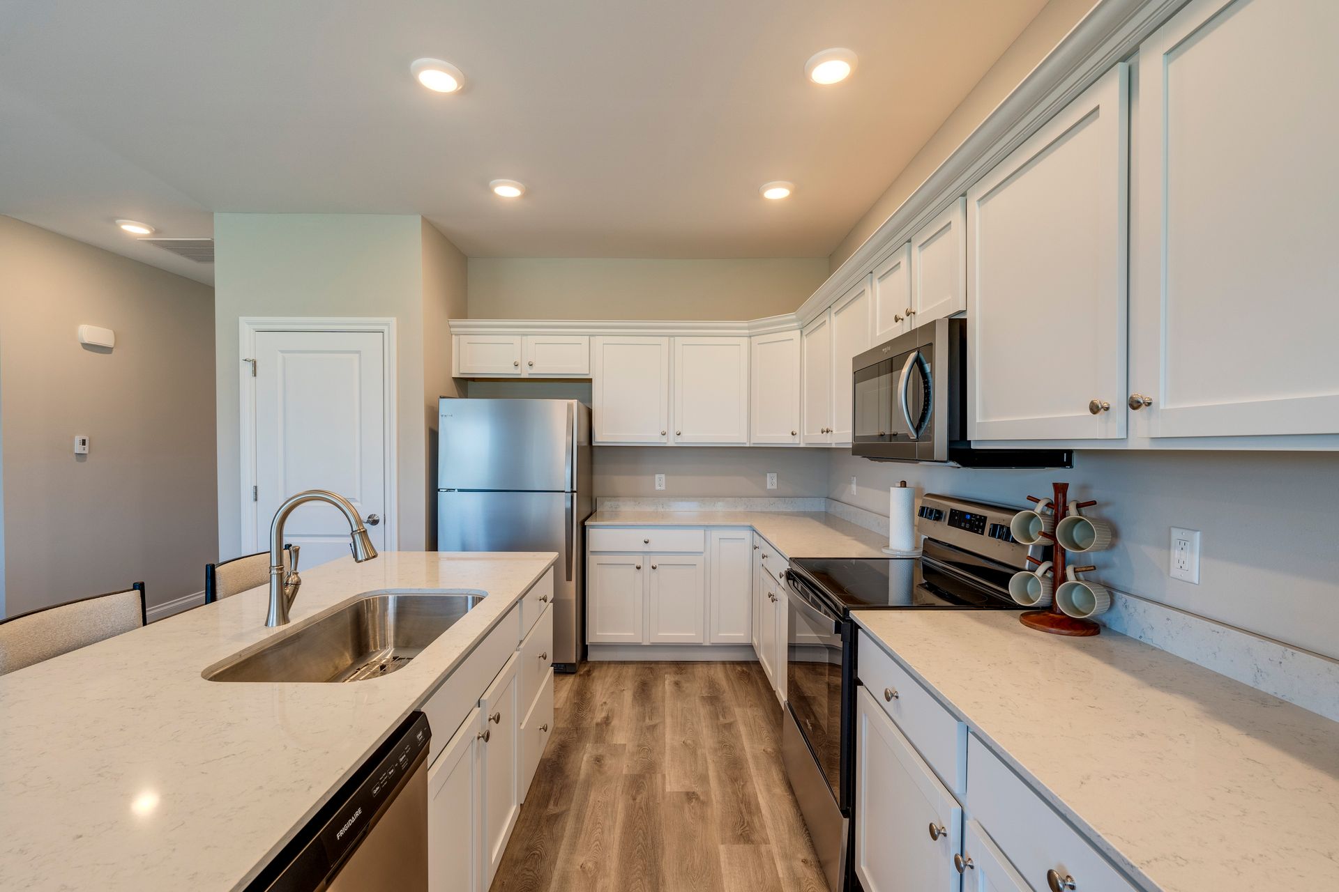Modern kitchen with white cabinets, stainless steel appliances, and a central island.