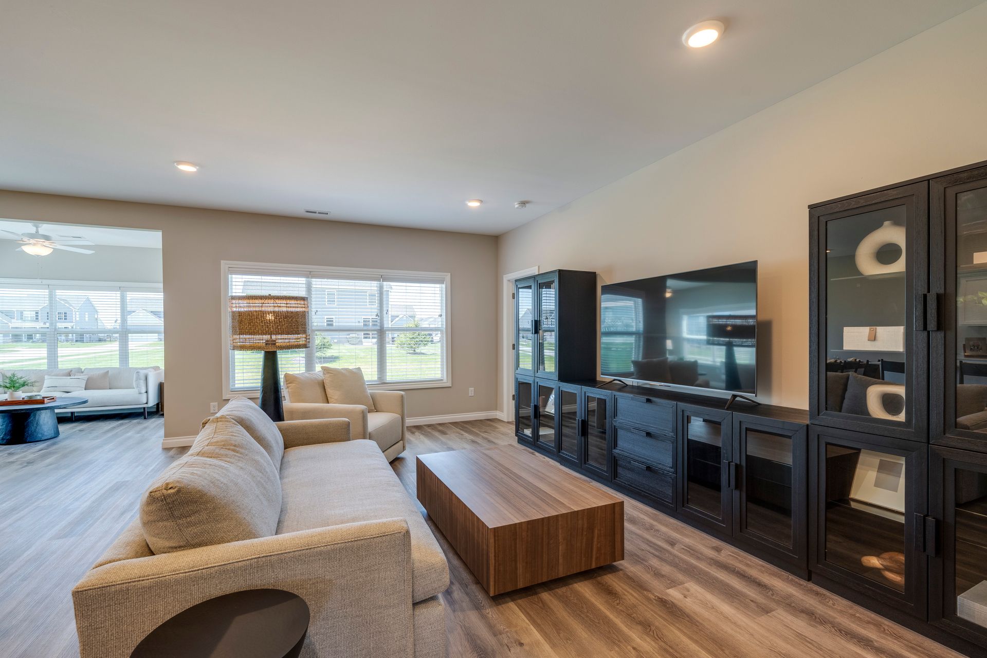 Living room with a large TV, sofa, and wood floor.