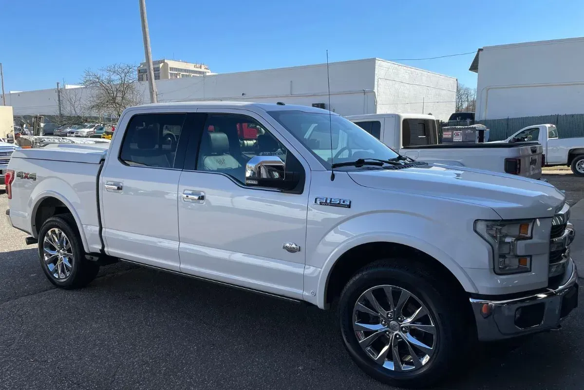 White Ford F-150 pickup truck with chrome accents parked on a sunny day.
