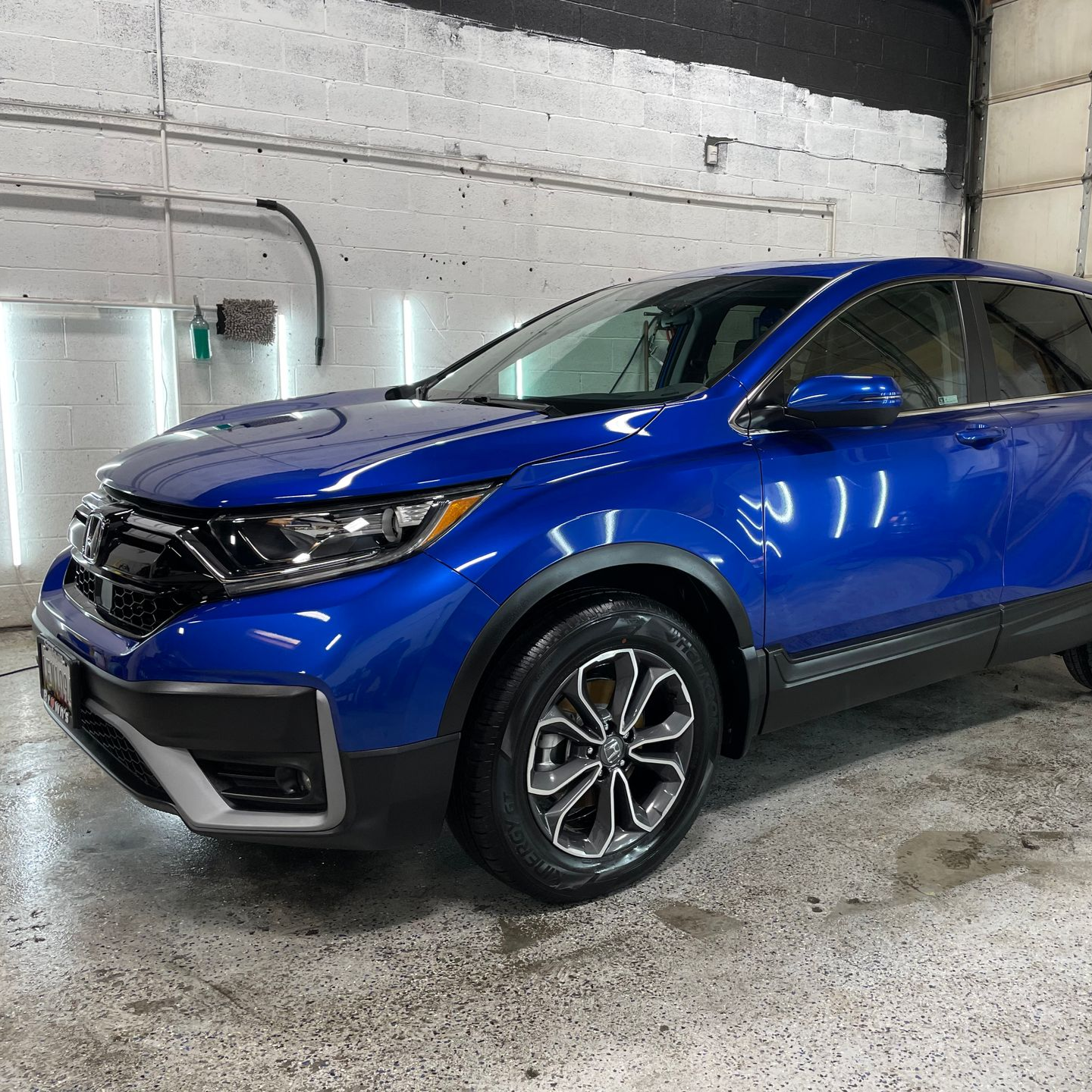 Blue Honda CRV in a car wash bay.