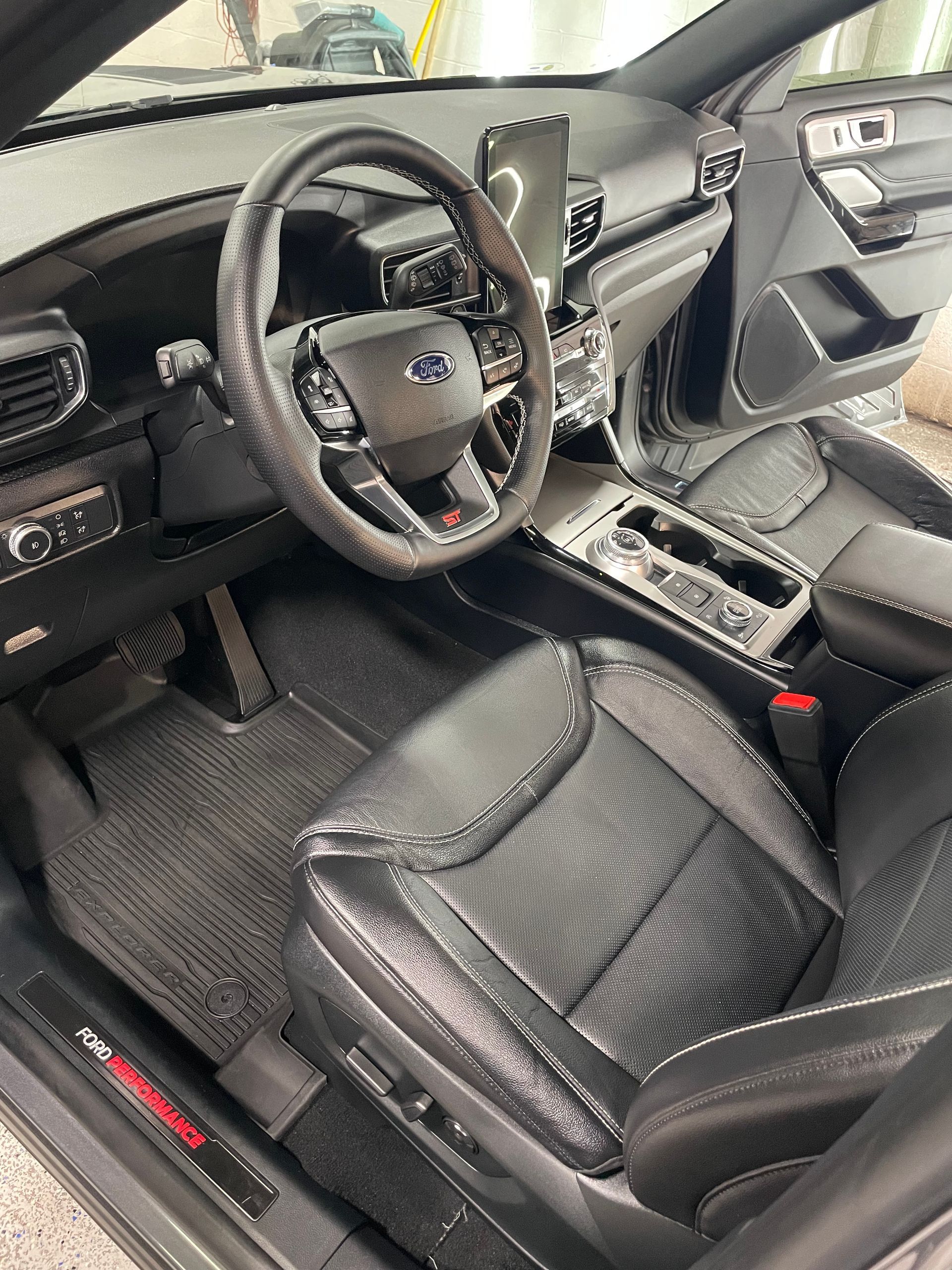 Interior view of a Ford Explorer ST, black leather seats, steering wheel, and dashboard.