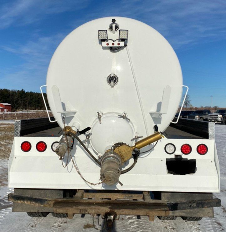 The back of a white truck with red lights on it