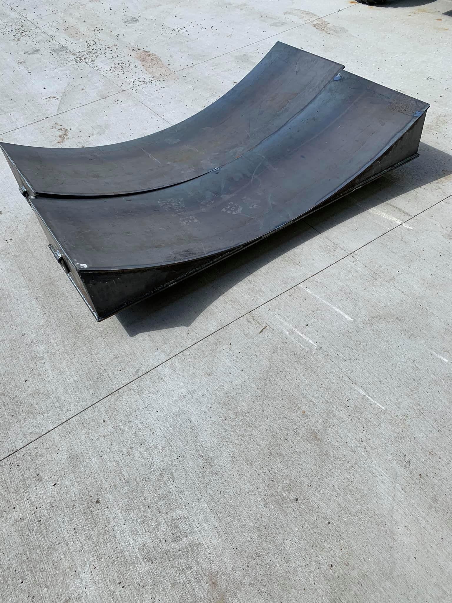 A piece of black rubber is laying on a concrete surface.