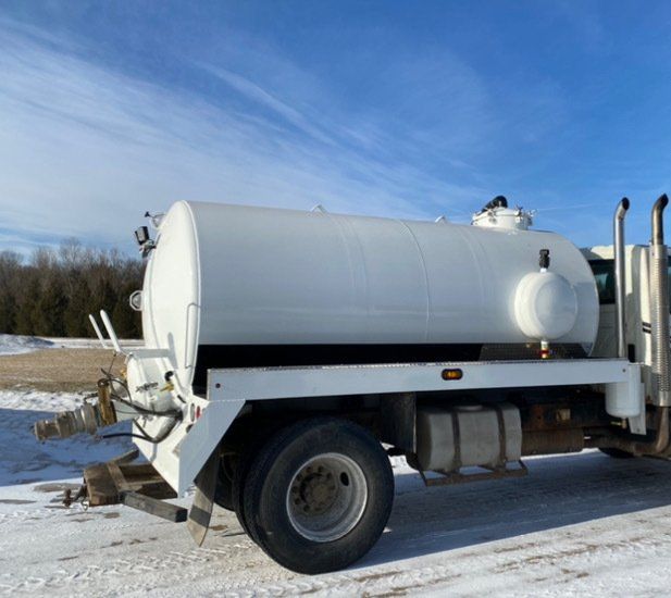 A large white truck is parked in the snow