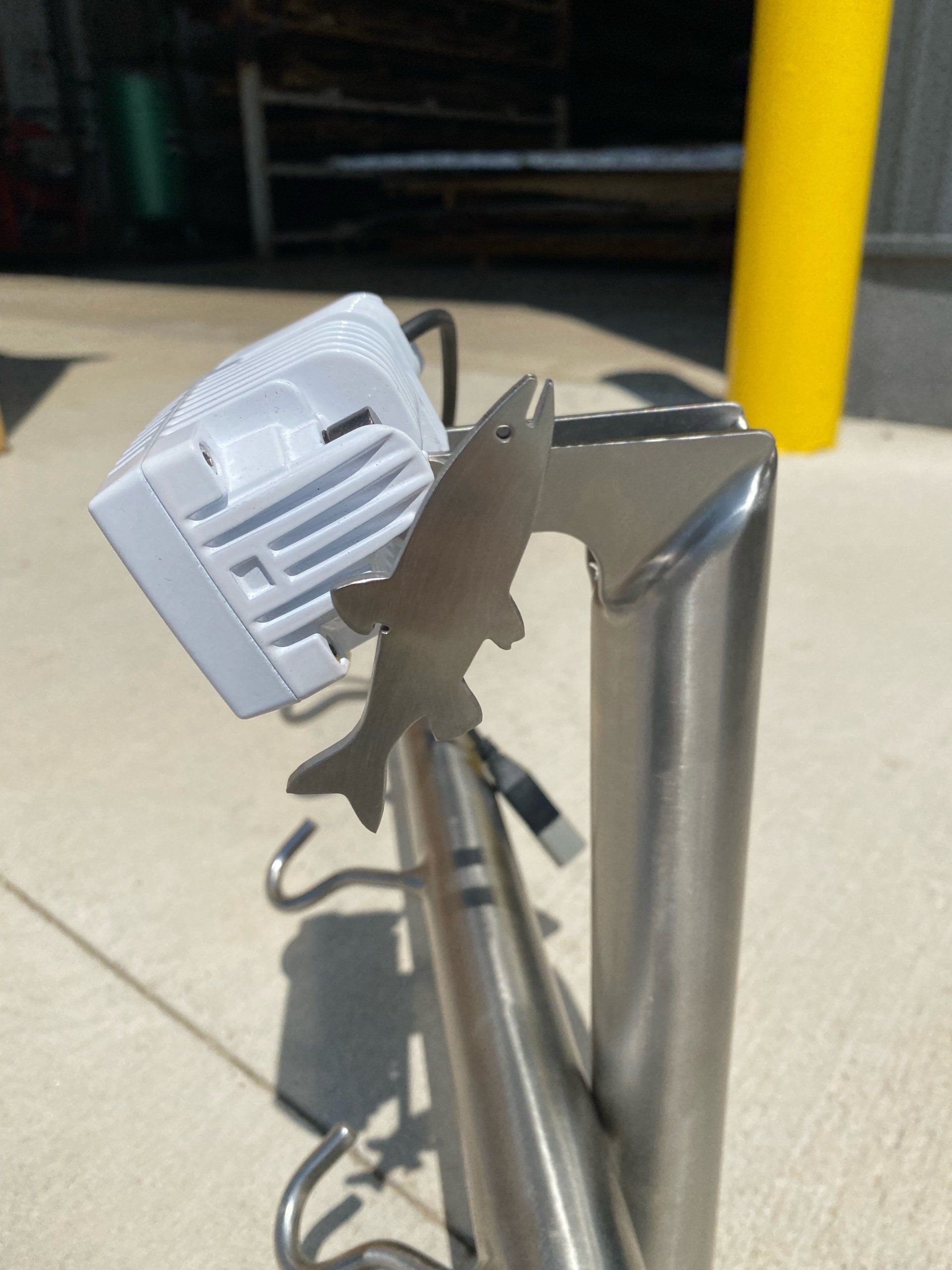 A stainless steel pole with a fish on it