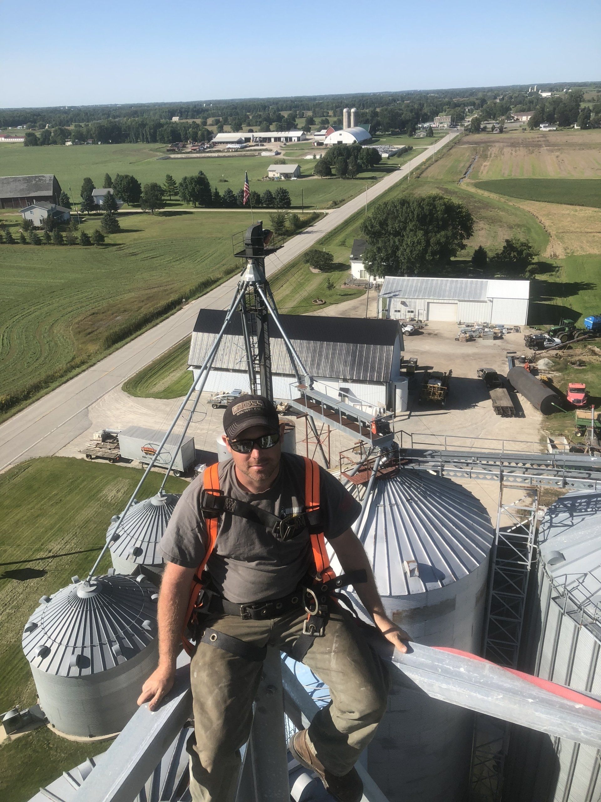 A man is sitting on top of a grain silo.