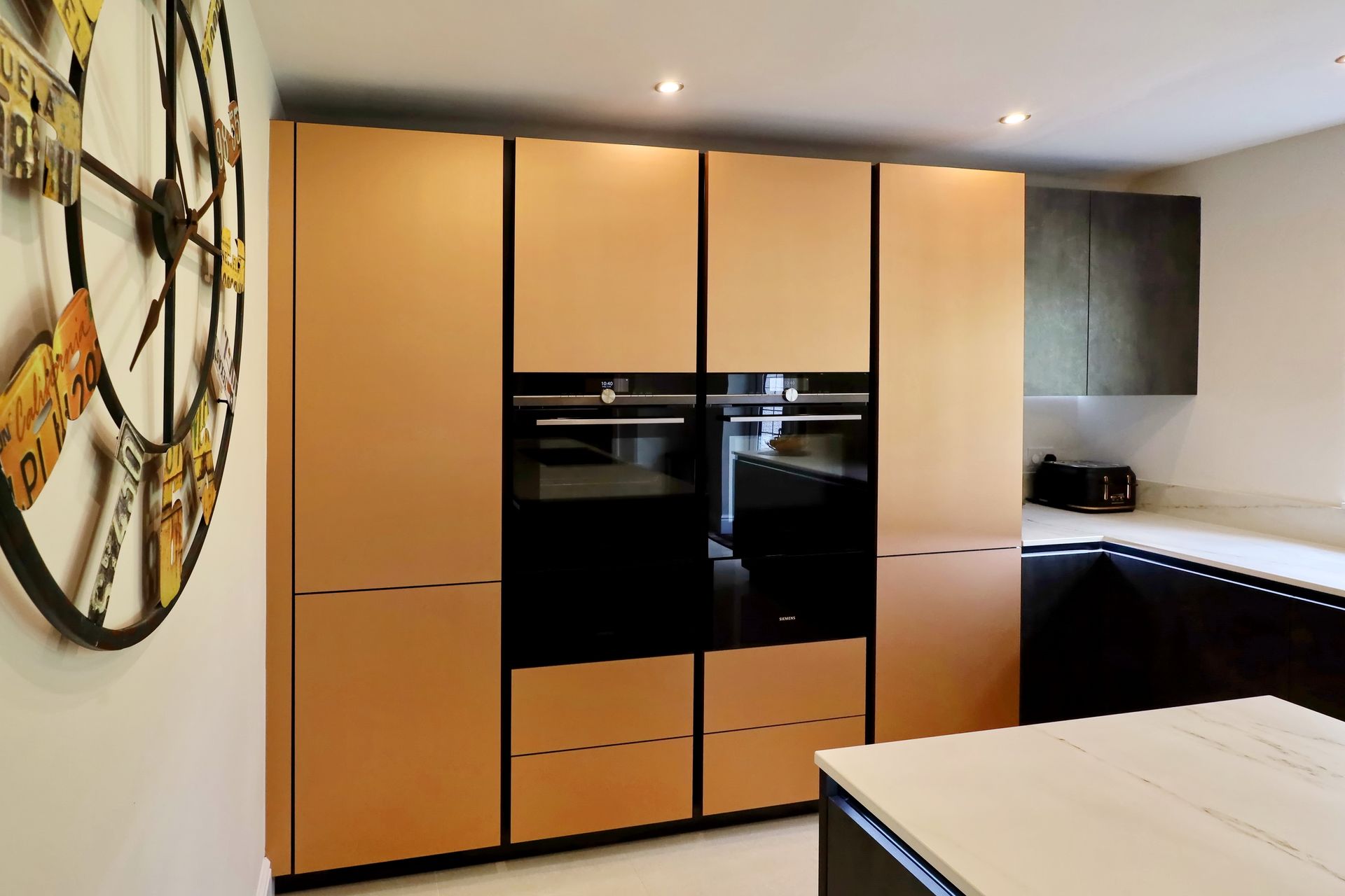 Harvey contemporary kitchen with grey, handleless units and teal furnishings. Designed by exact Kitchens in Wokingham.