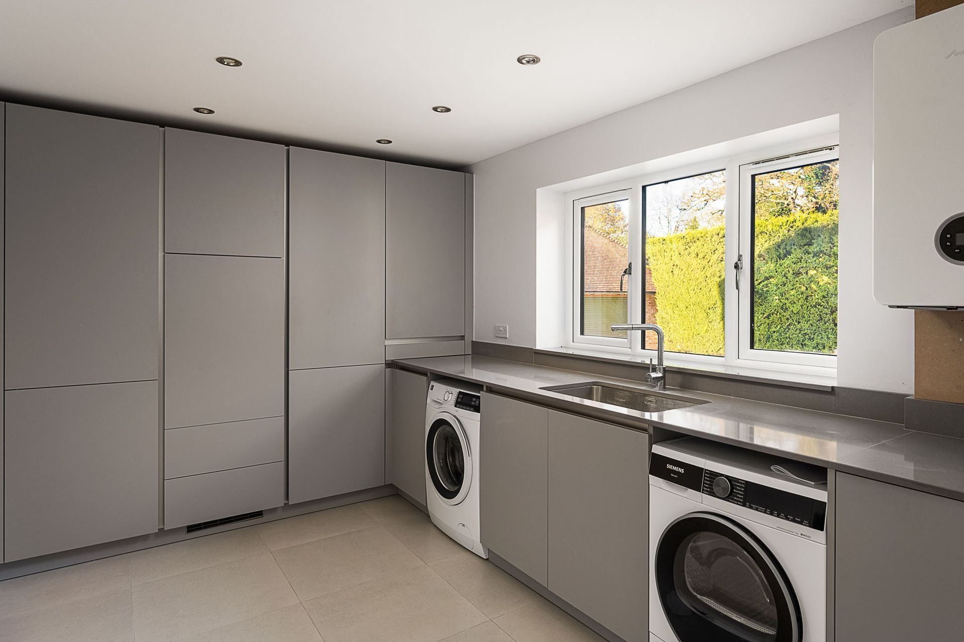 Harvey contemporary kitchen with grey, handleless units and teal furnishings. Designed by exact Kitchens in Wokingham.