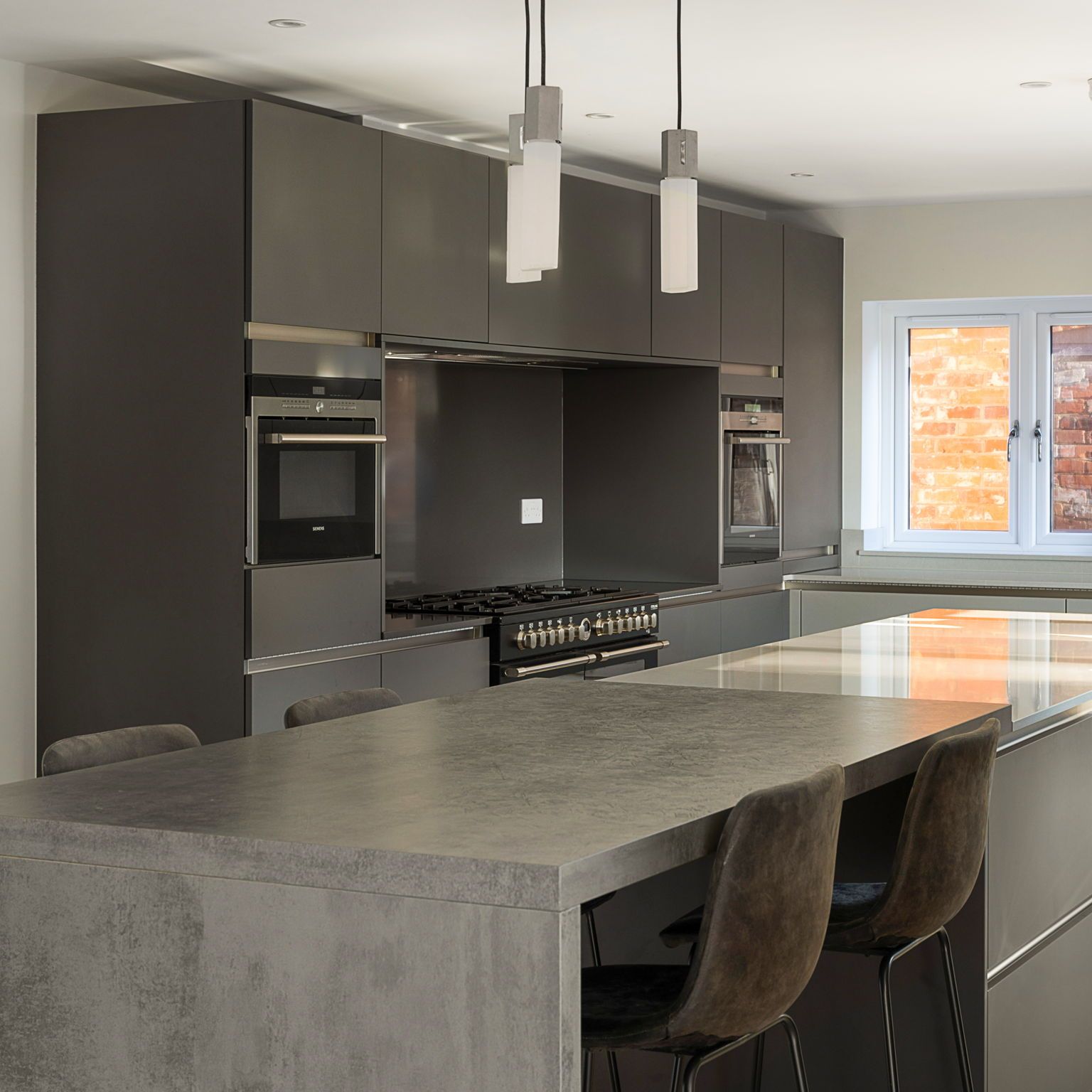 Harvey contemporary kitchen with grey, handleless units and teal furnishings. Designed by exact Kitchens in Wokingham.