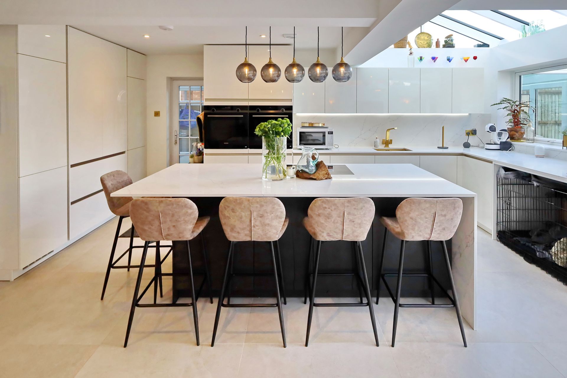 A bright modern kitchen by exact kitchens, Wokingham with tall chairs around a large kitchen island