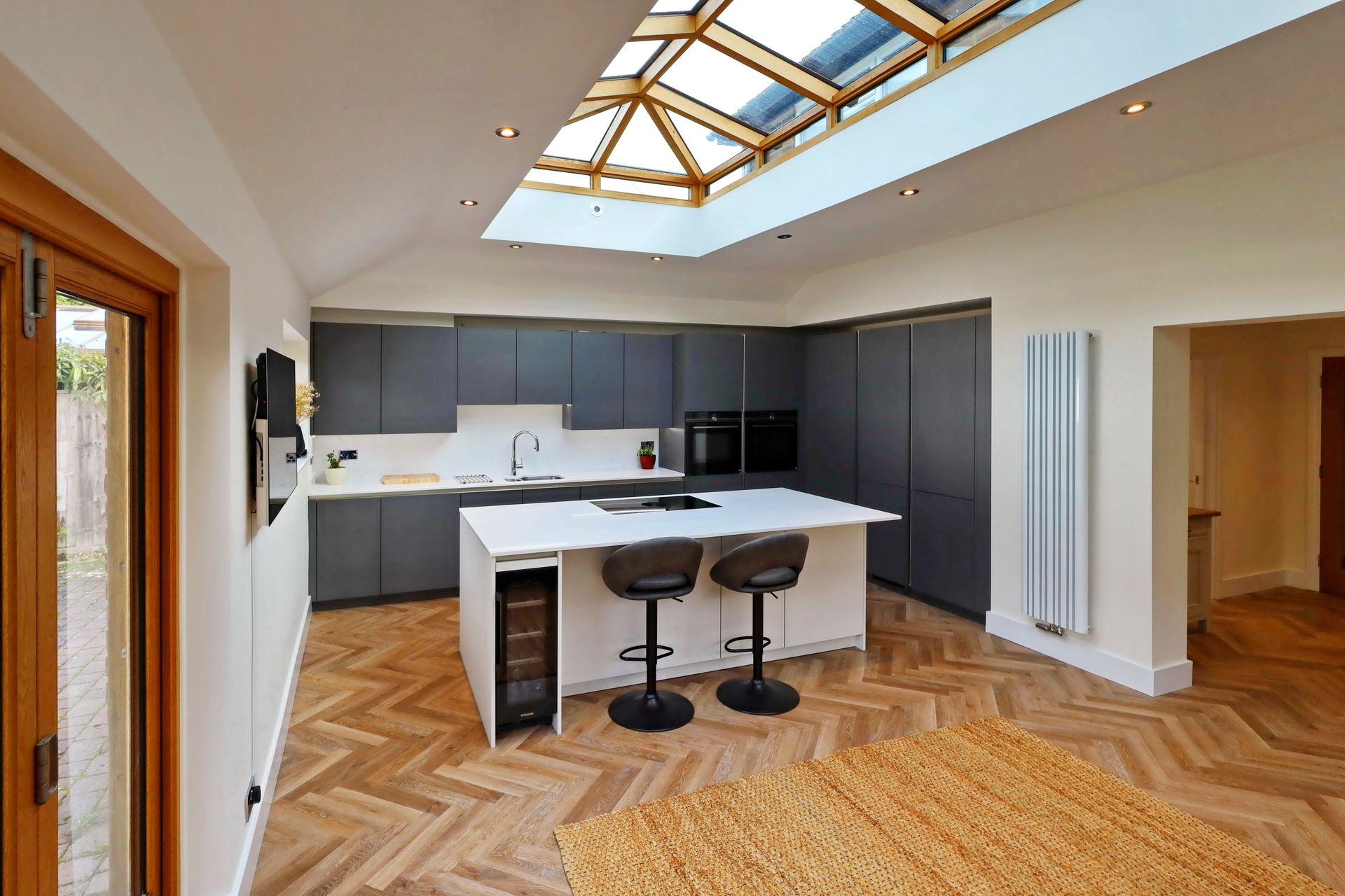 Harvey contemporary kitchen with grey, handleless units and teal furnishings. Designed by exact Kitchens in Wokingham.