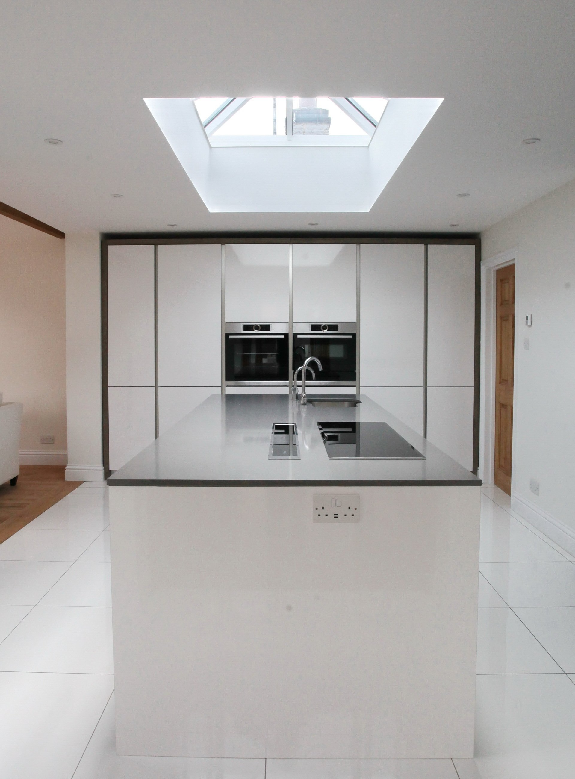 Contemporary handleless kitchen with large skylight by exact