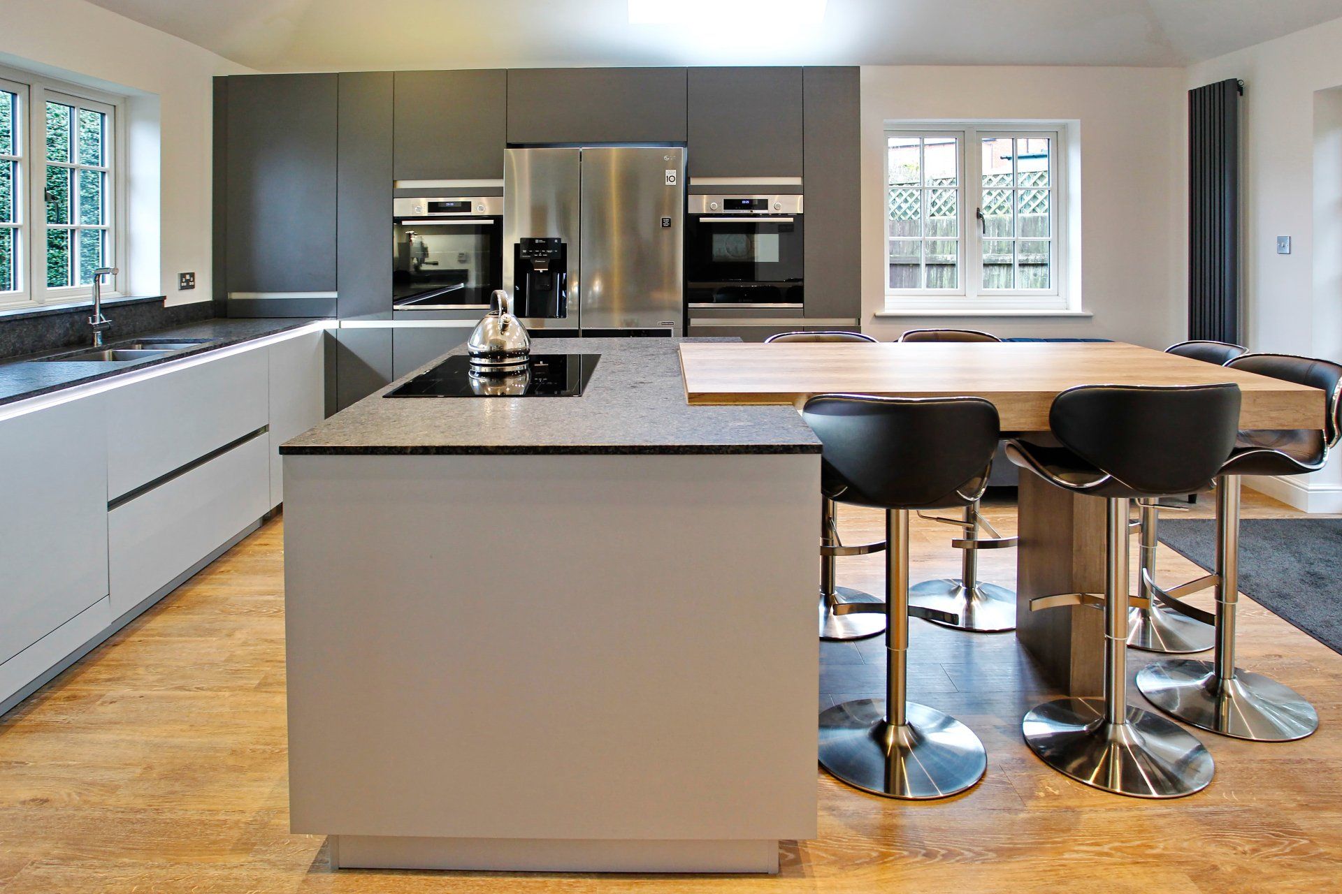 Harvey contemporary kitchen with grey, handleless units and teal furnishings. Designed by exact Kitchens in Wokingham.