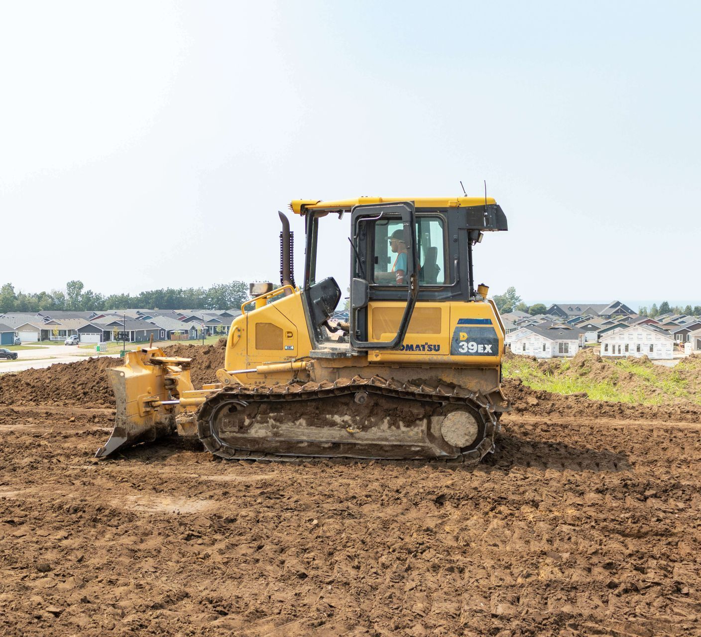 A bulldozer is driving through a muddy field.