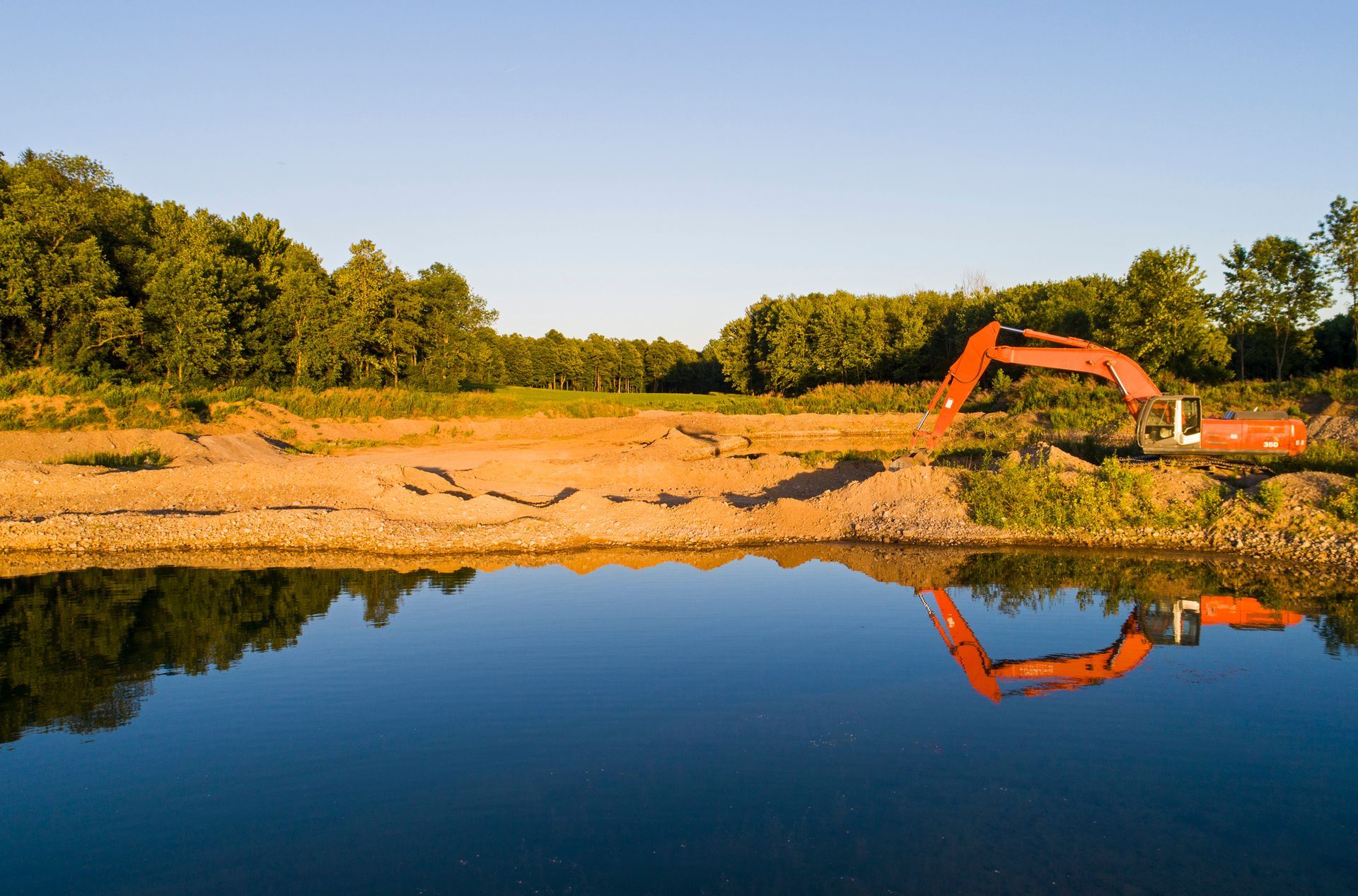 A large excavator is digging a trench in the dirt.