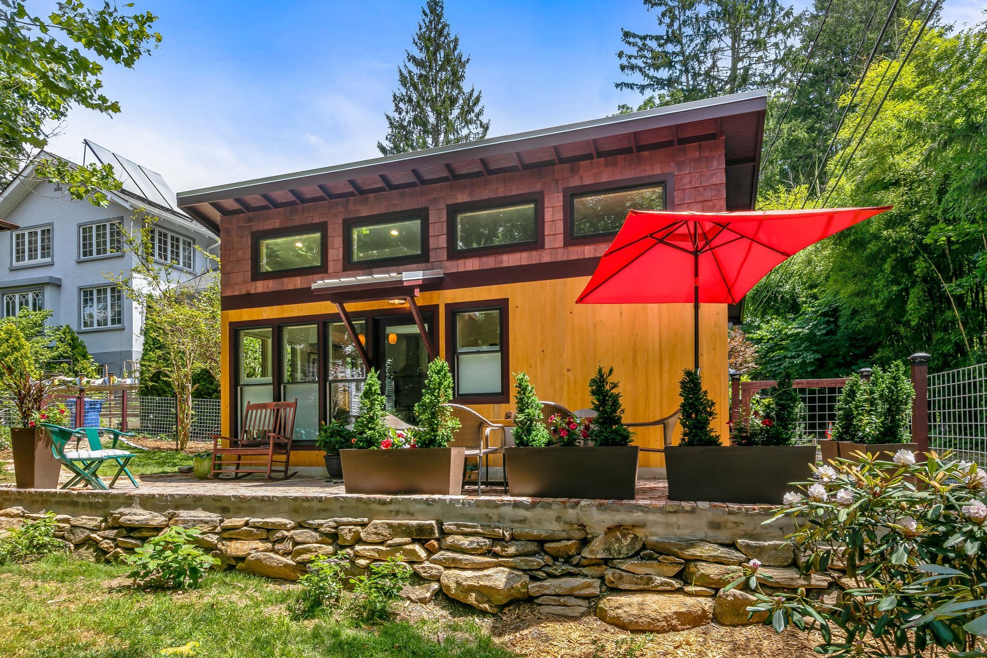 A small house with a red umbrella in front of it.