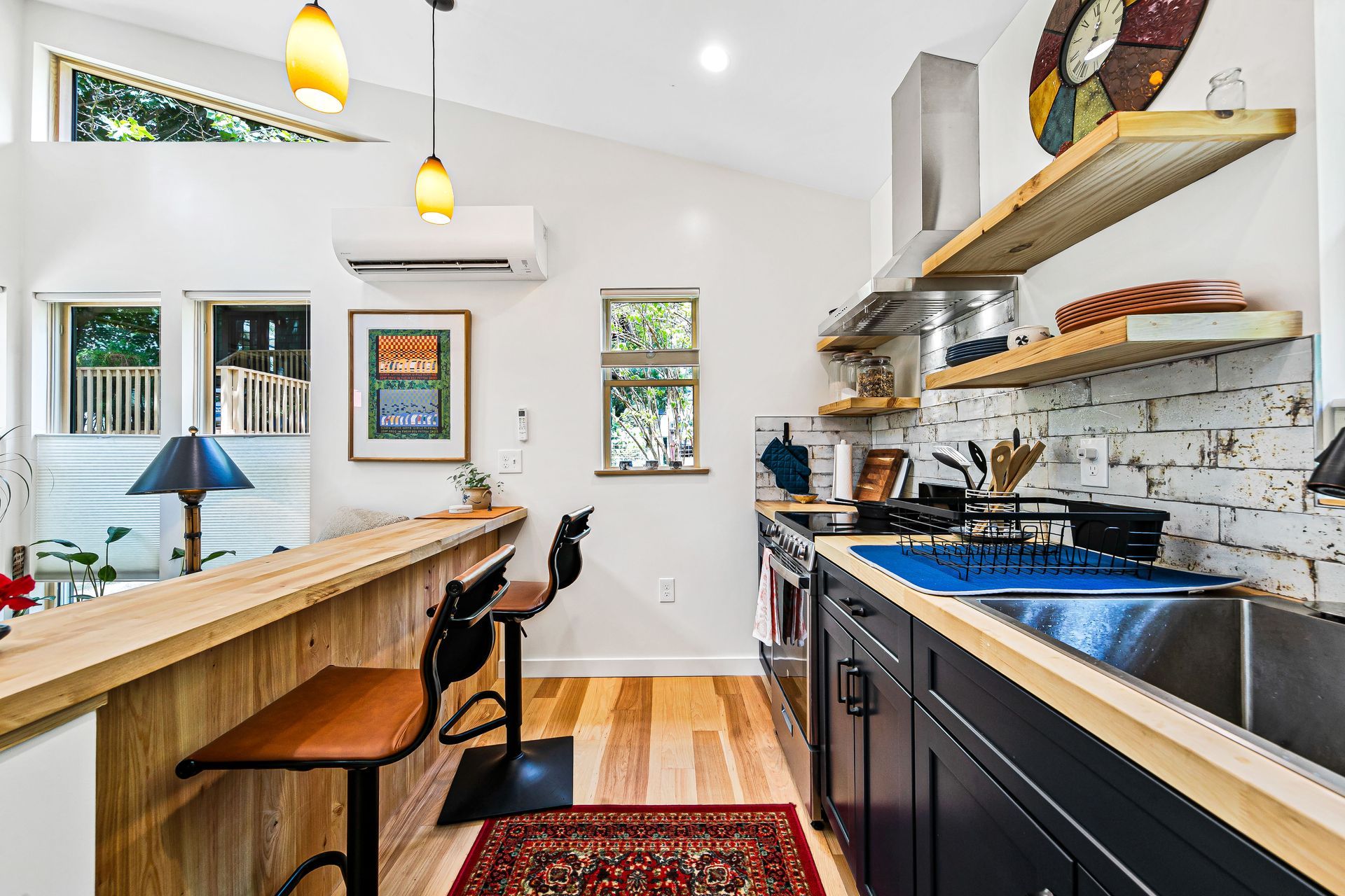 A kitchen with stainless steel appliances and a wooden counter top.