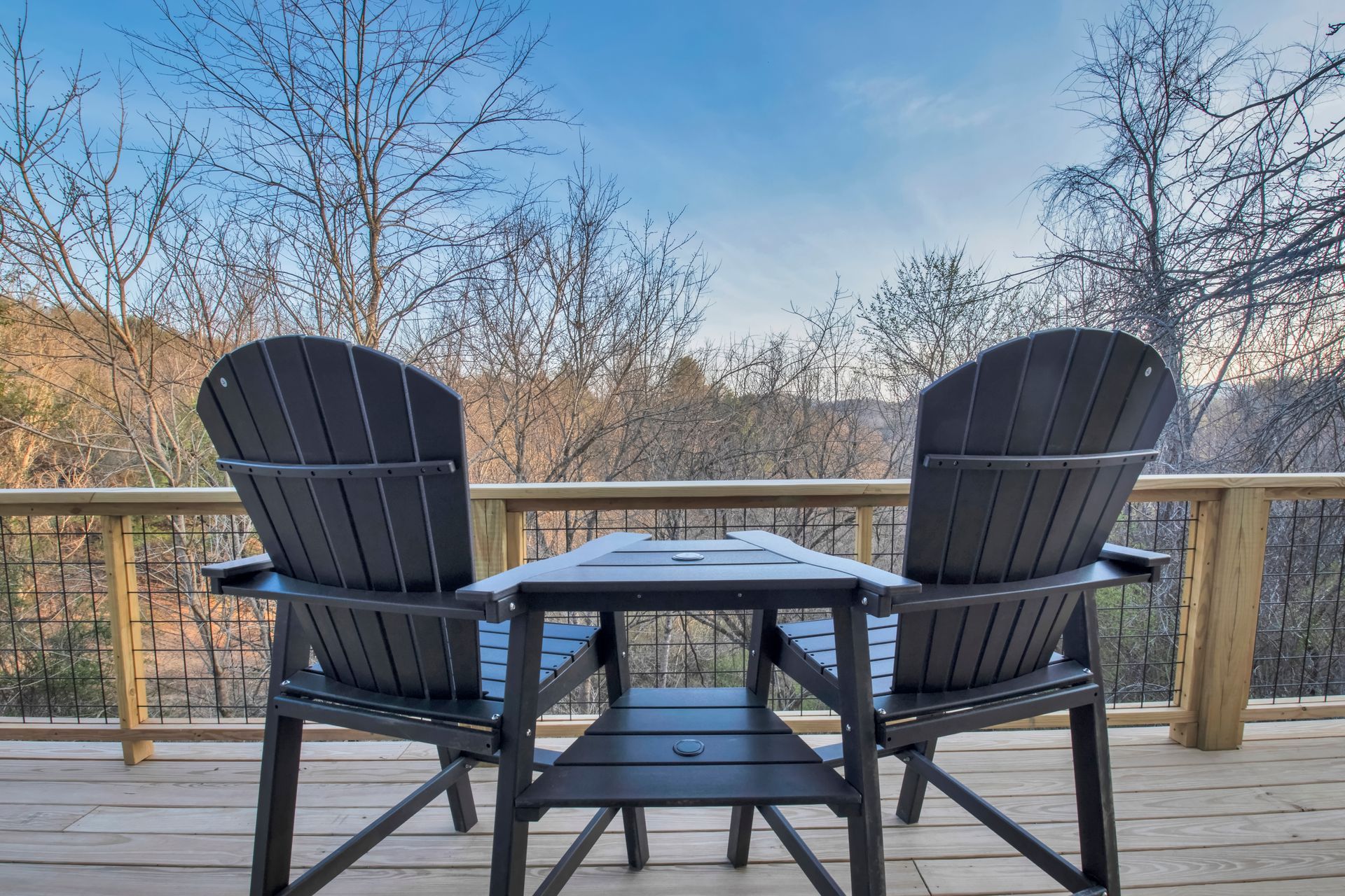 There are two chairs and a table on the deck.