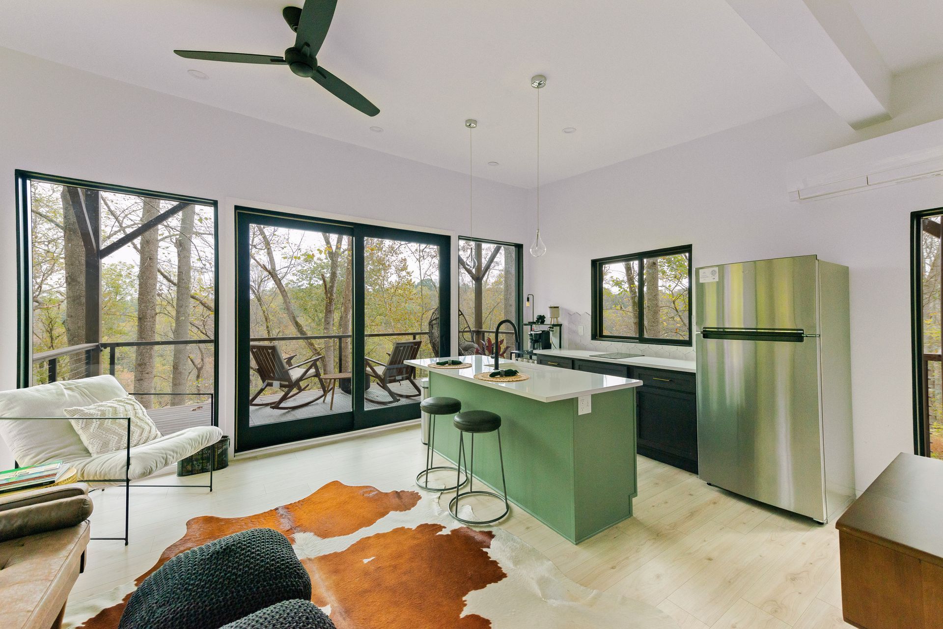 A living room with a cowhide rug and a ceiling fan.