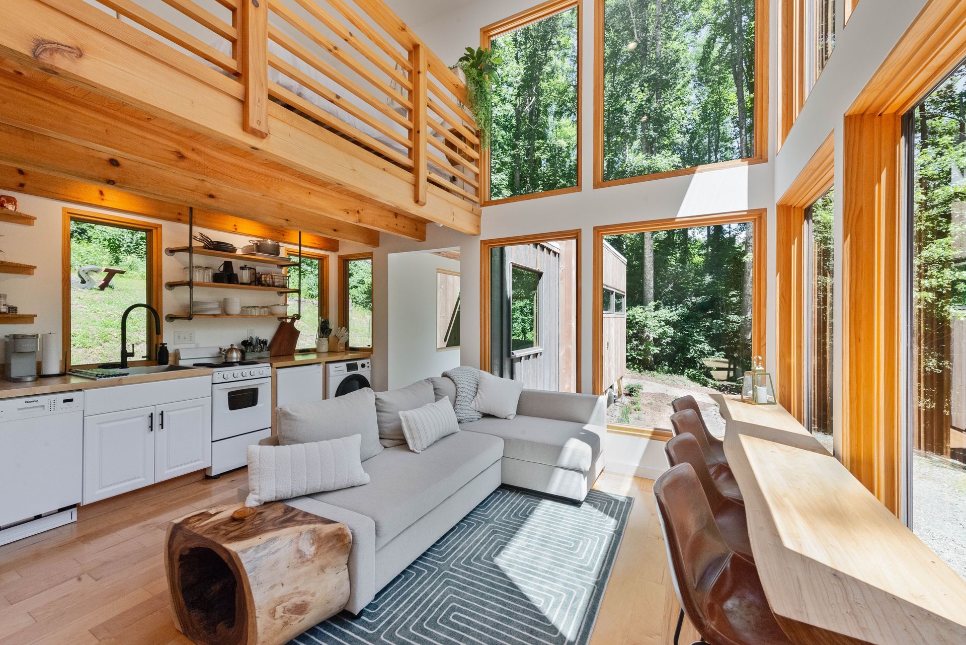 A living room with a couch and a kitchen in a cabin.