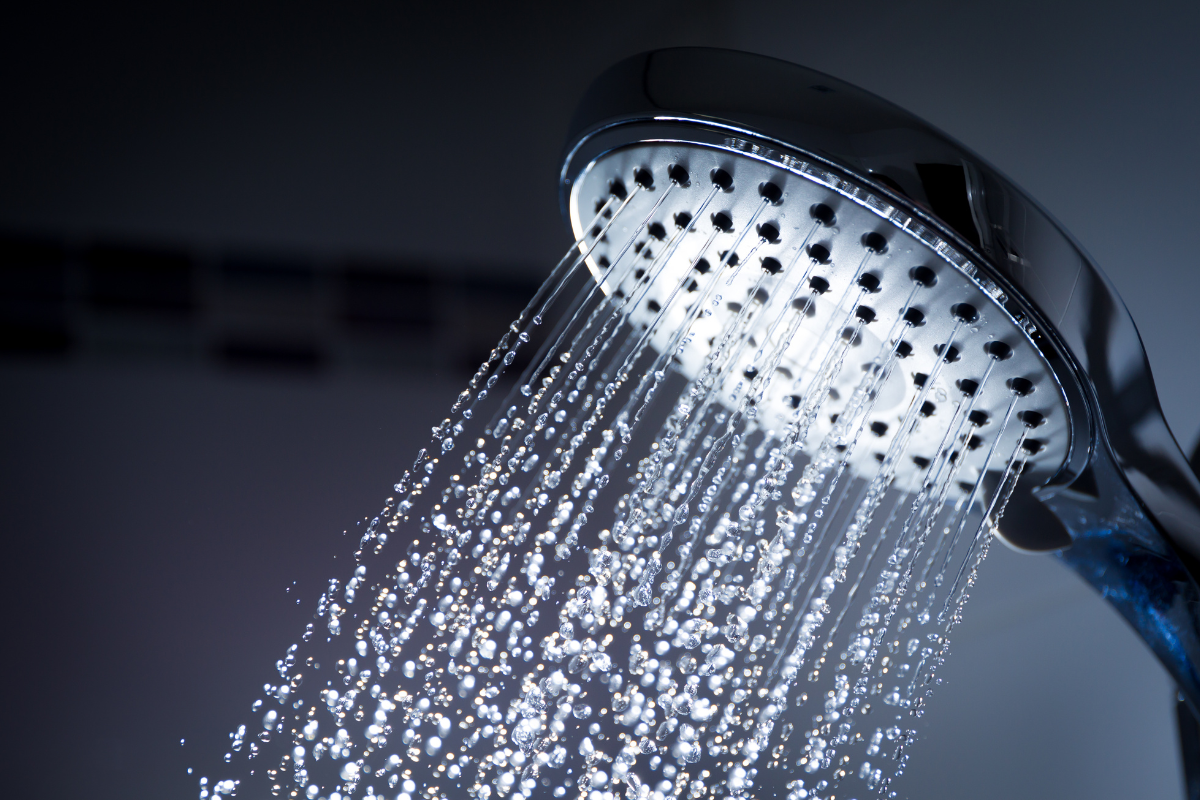 A close up of a shower head with water coming out of it.