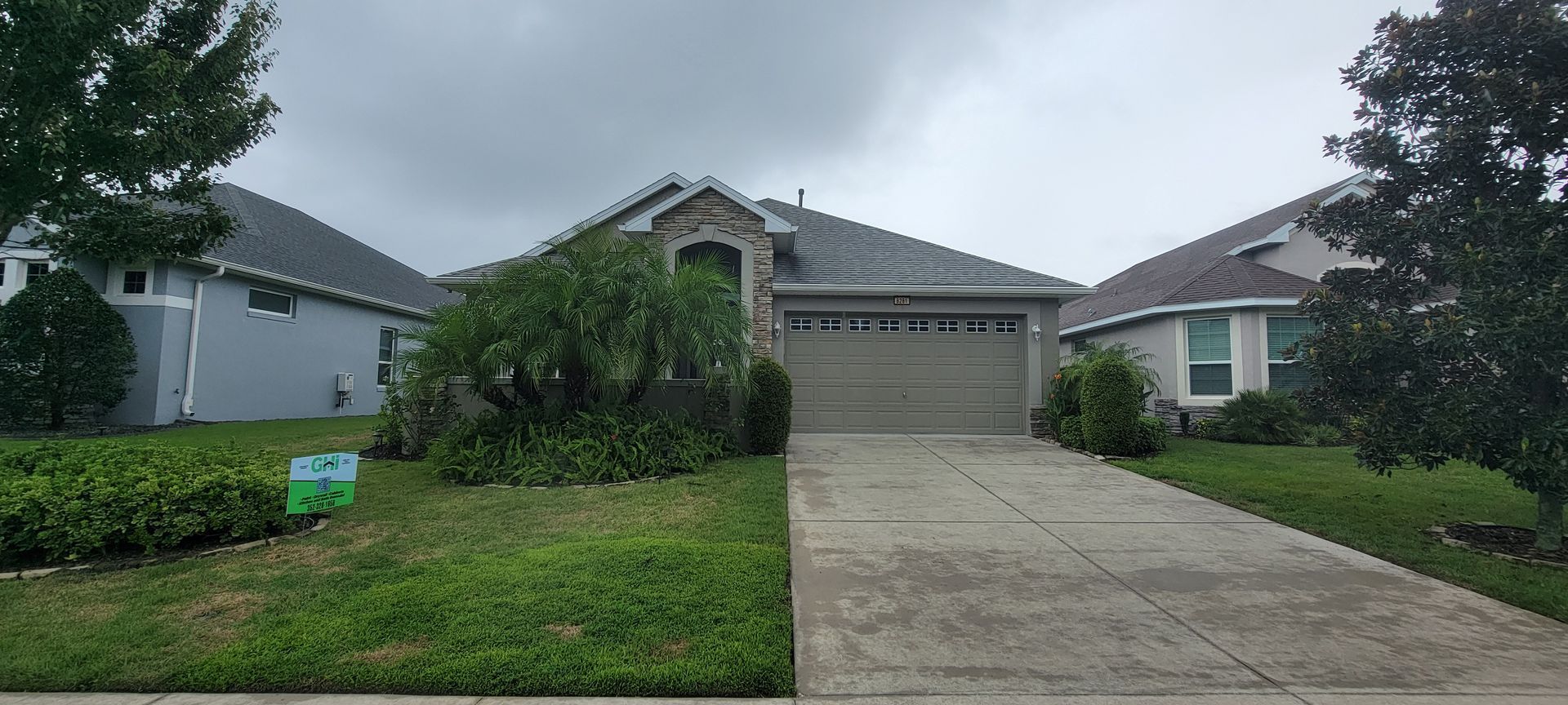 A house with a garage and a driveway in front of it.