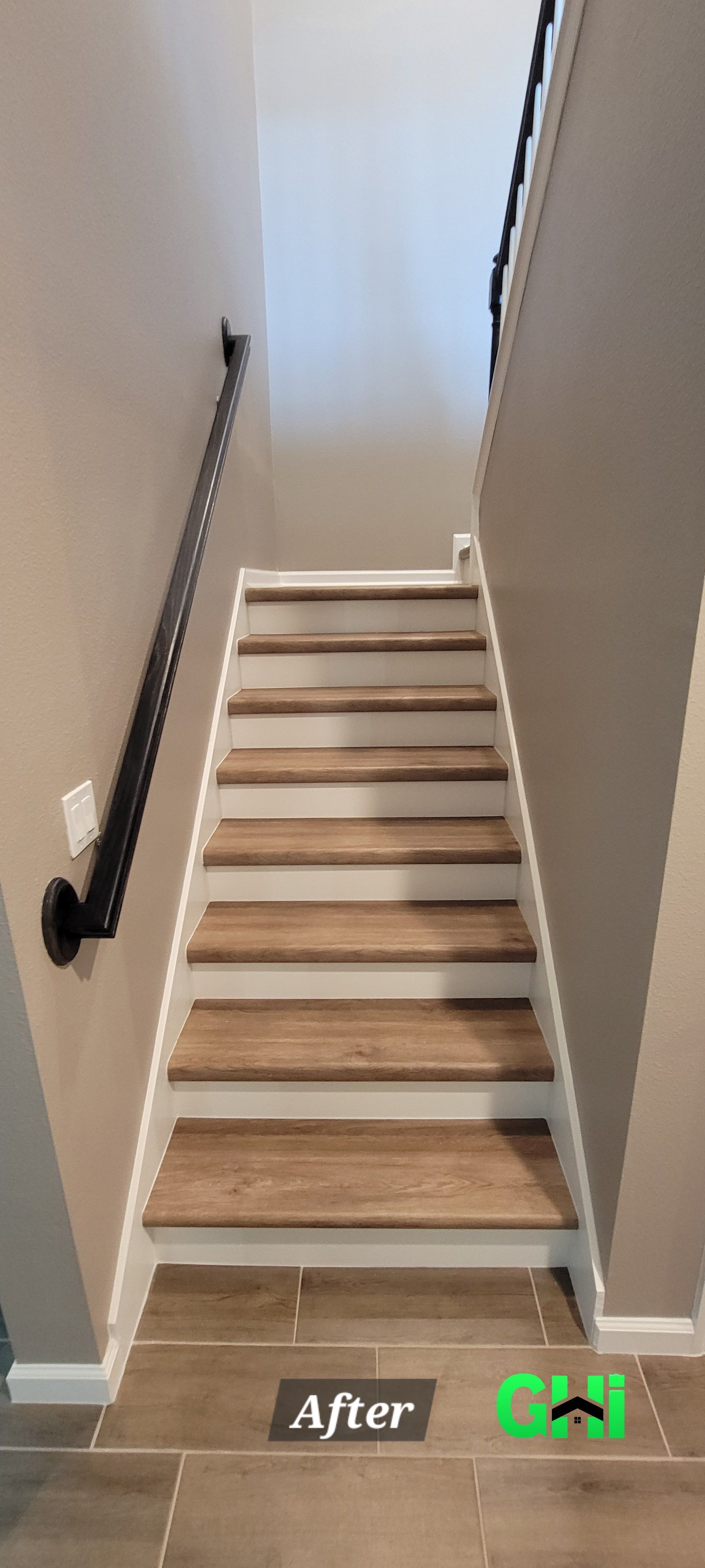 A picture of a staircase with wooden steps and a white railing.