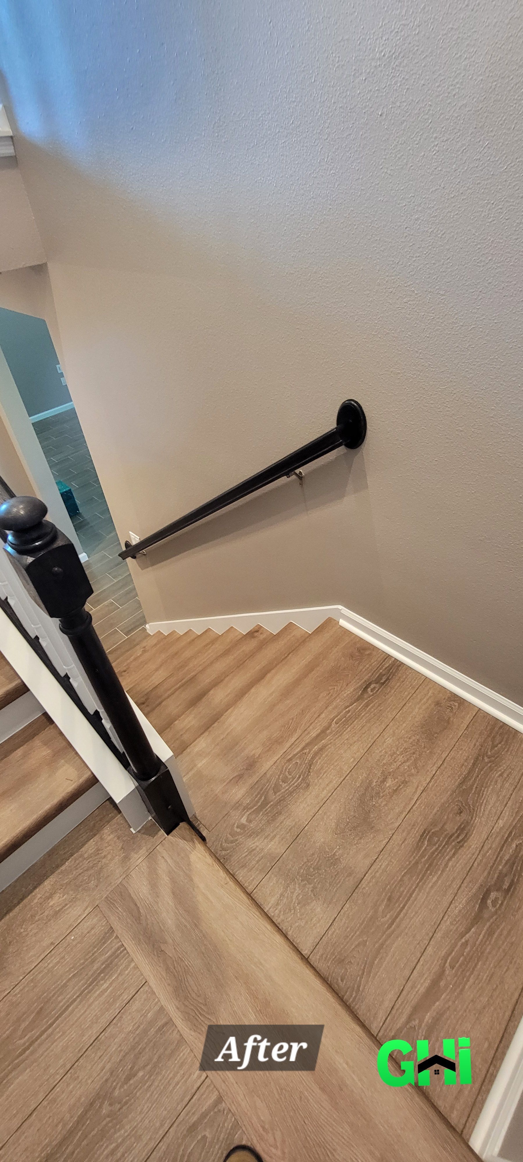 A staircase with wooden steps and a black railing.