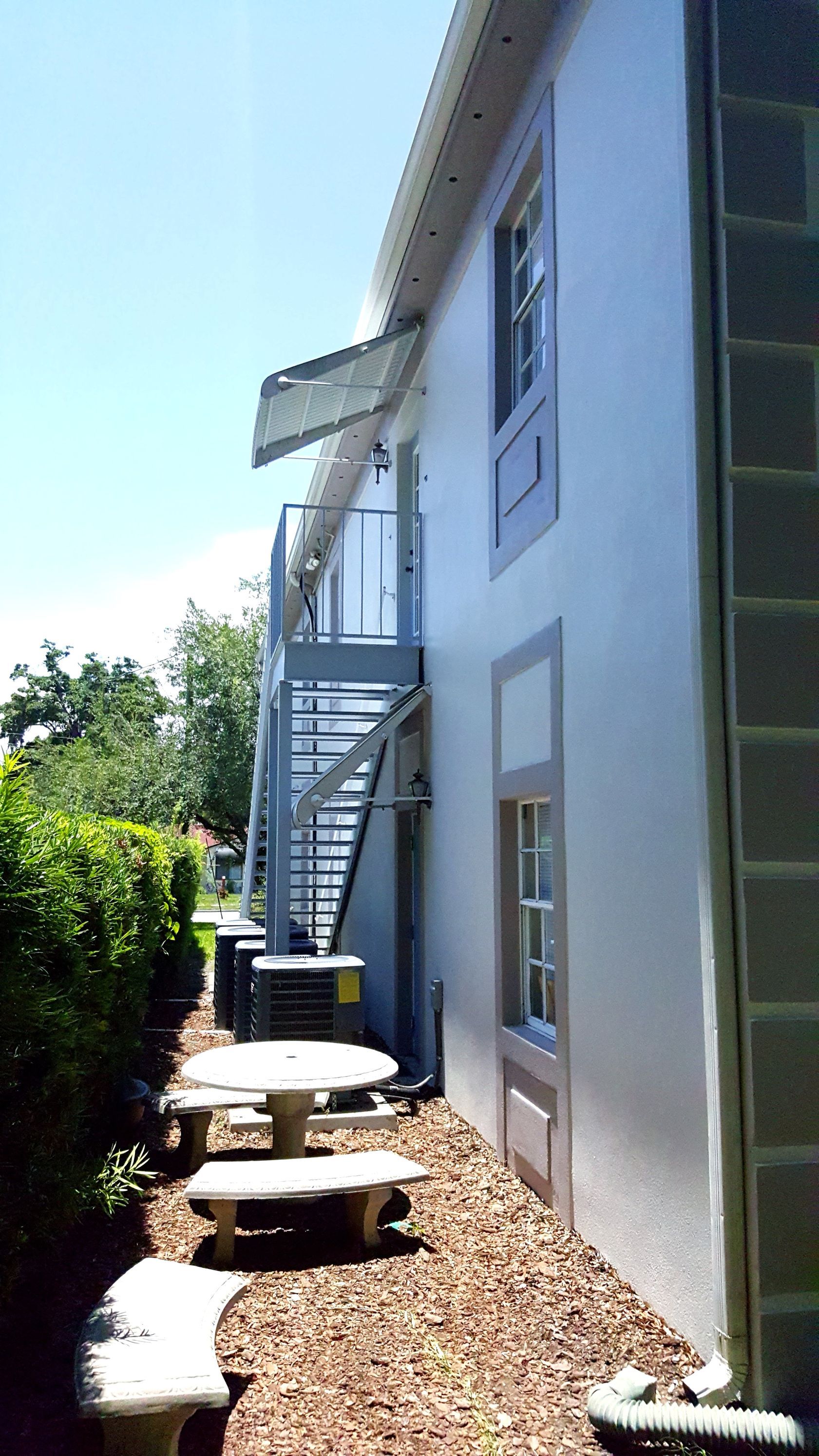 A white building with stairs leading up to the second floor