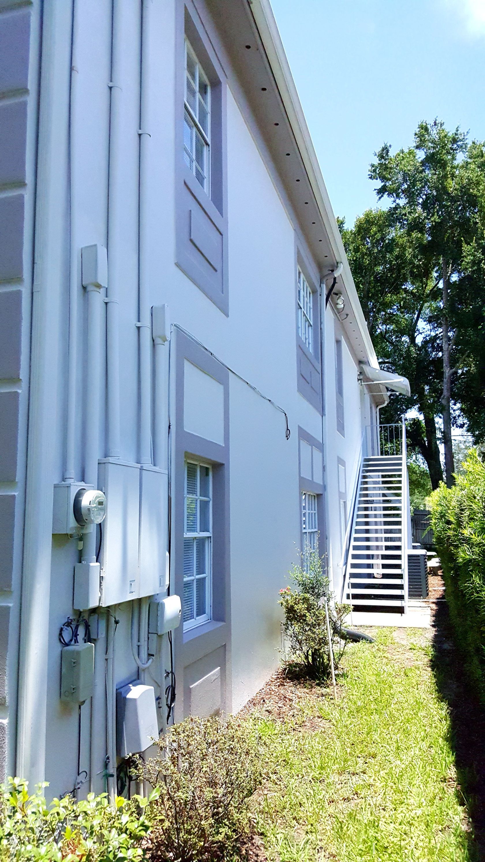 A white building with stairs leading up to the second floor