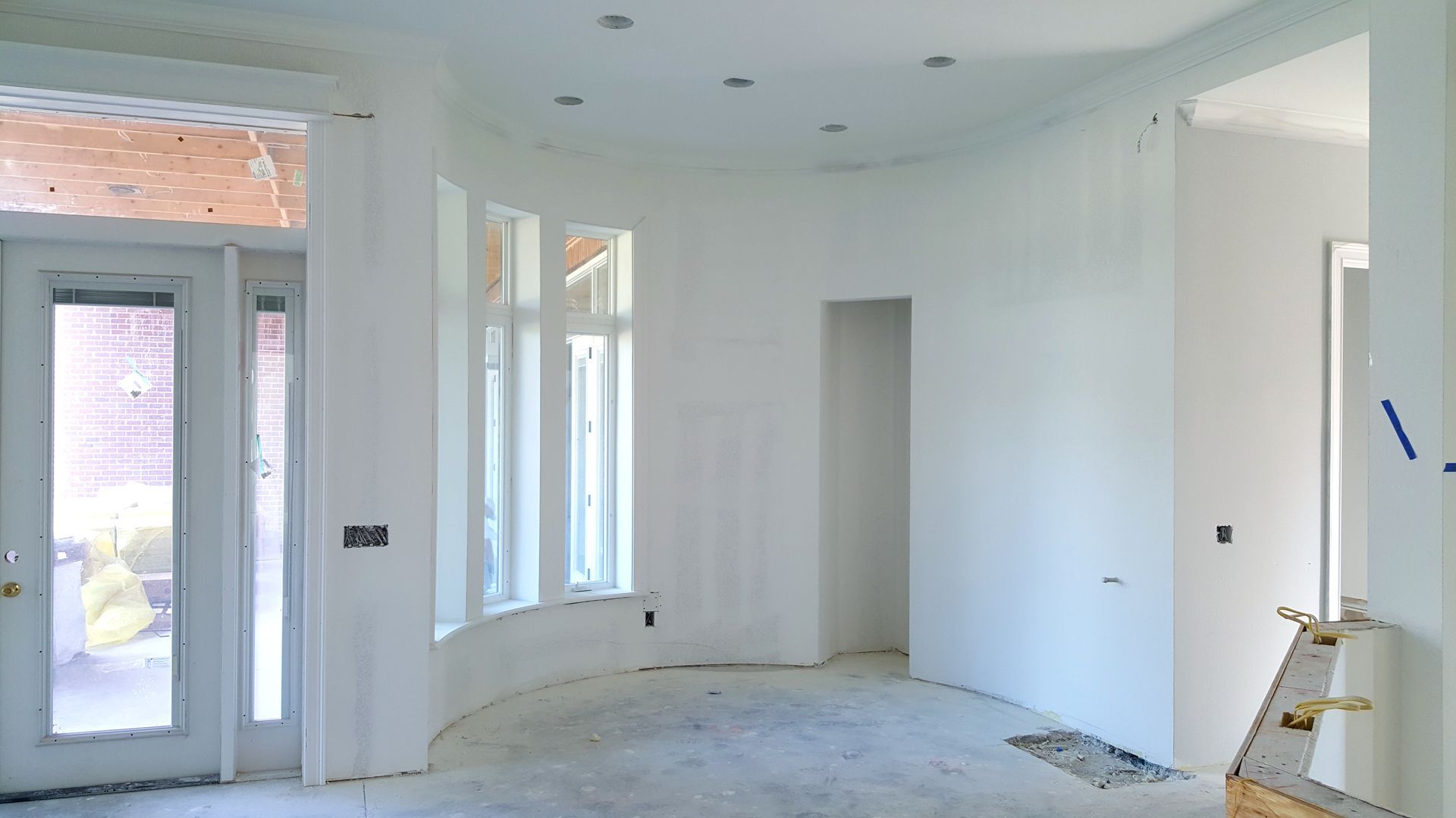 An empty room with white walls and a door