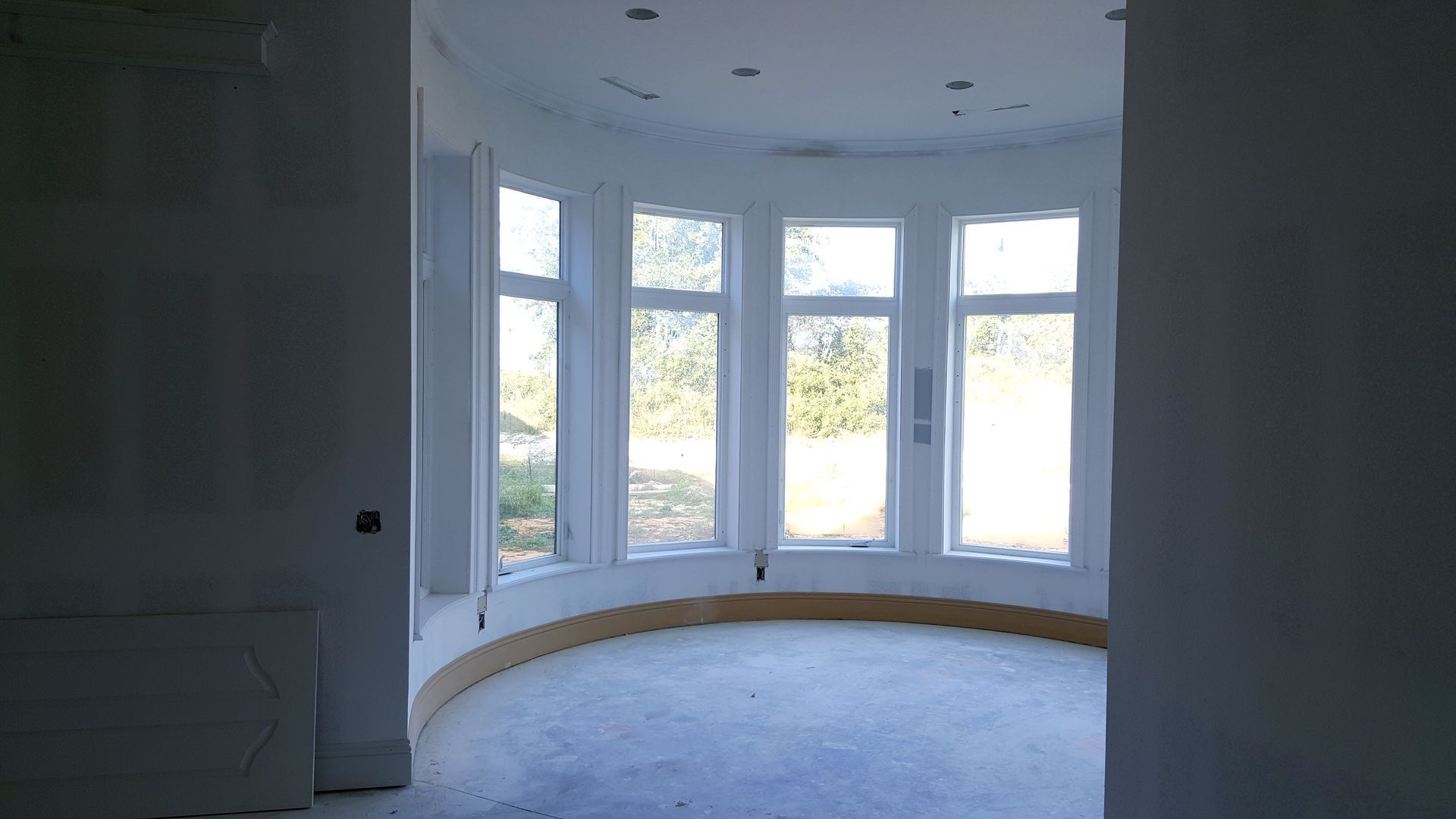 An empty room with a lot of windows and a curved floor.