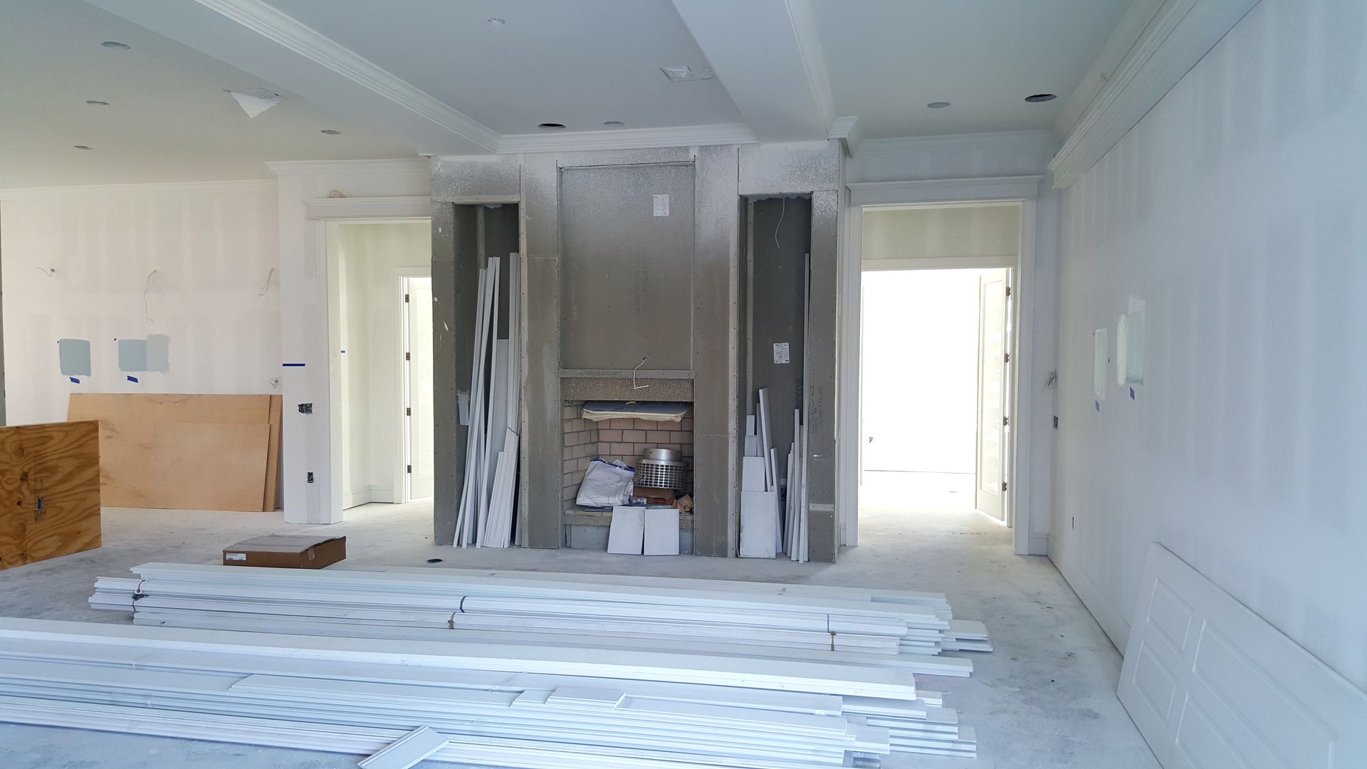 A large empty room with a fireplace in the middle of it.