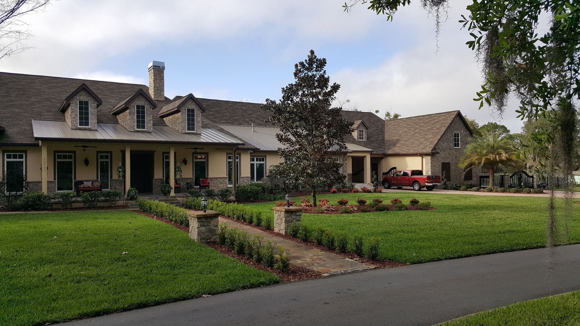 A large house with a red truck parked in front of it