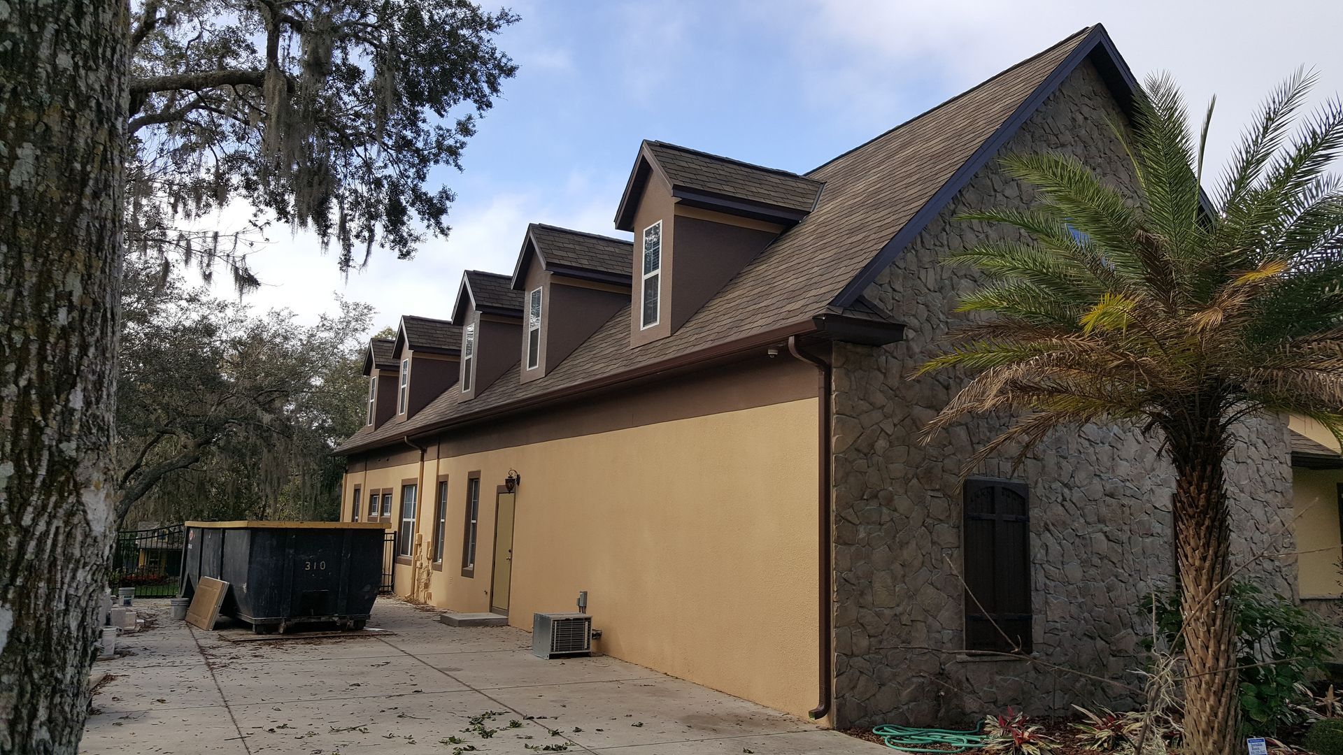 A large house with a lot of windows and a palm tree in front of it.