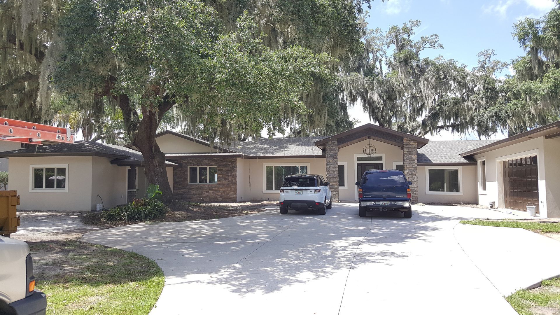 Two cars are parked in front of a large house