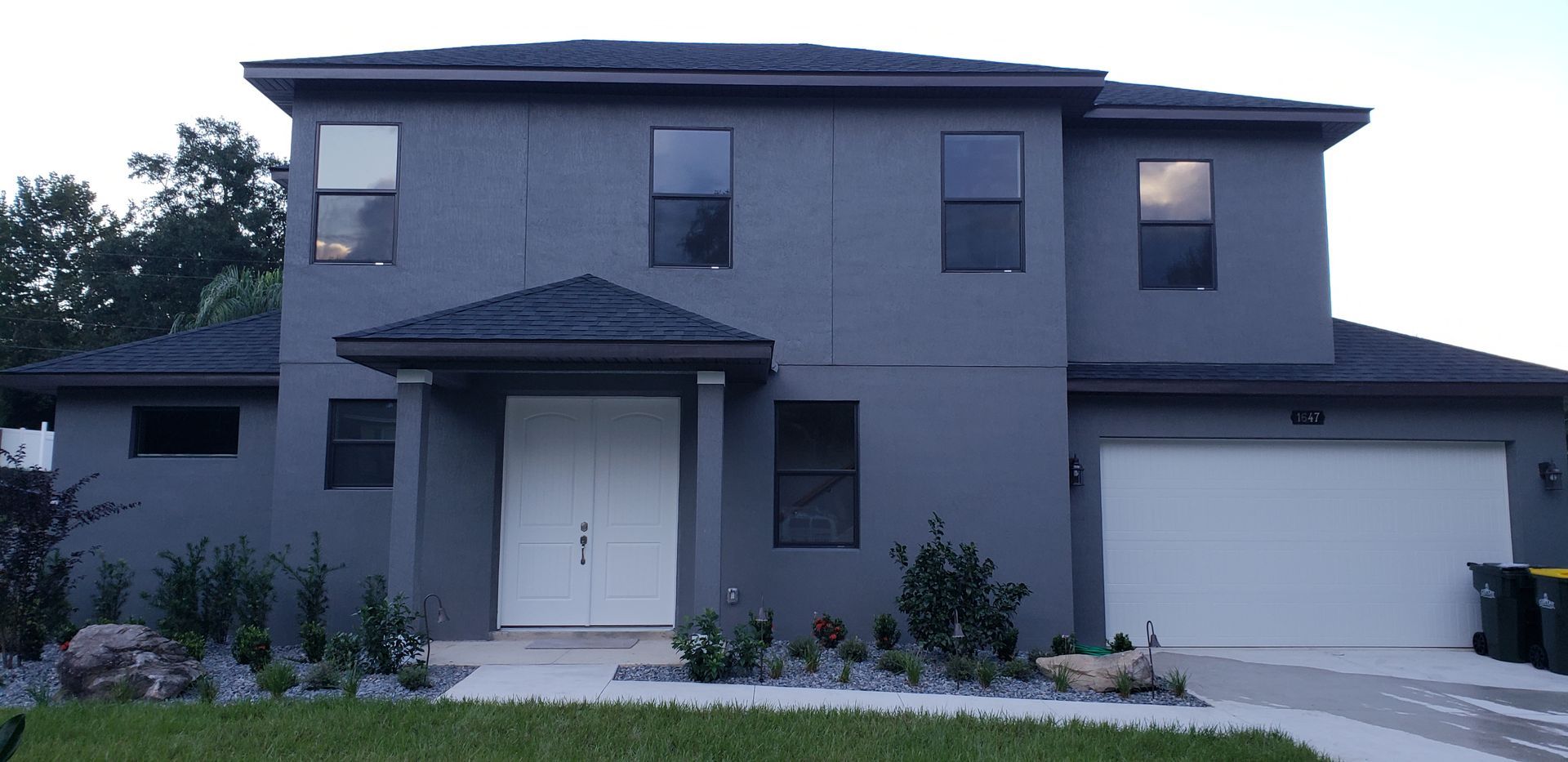 A large gray house with a white garage door