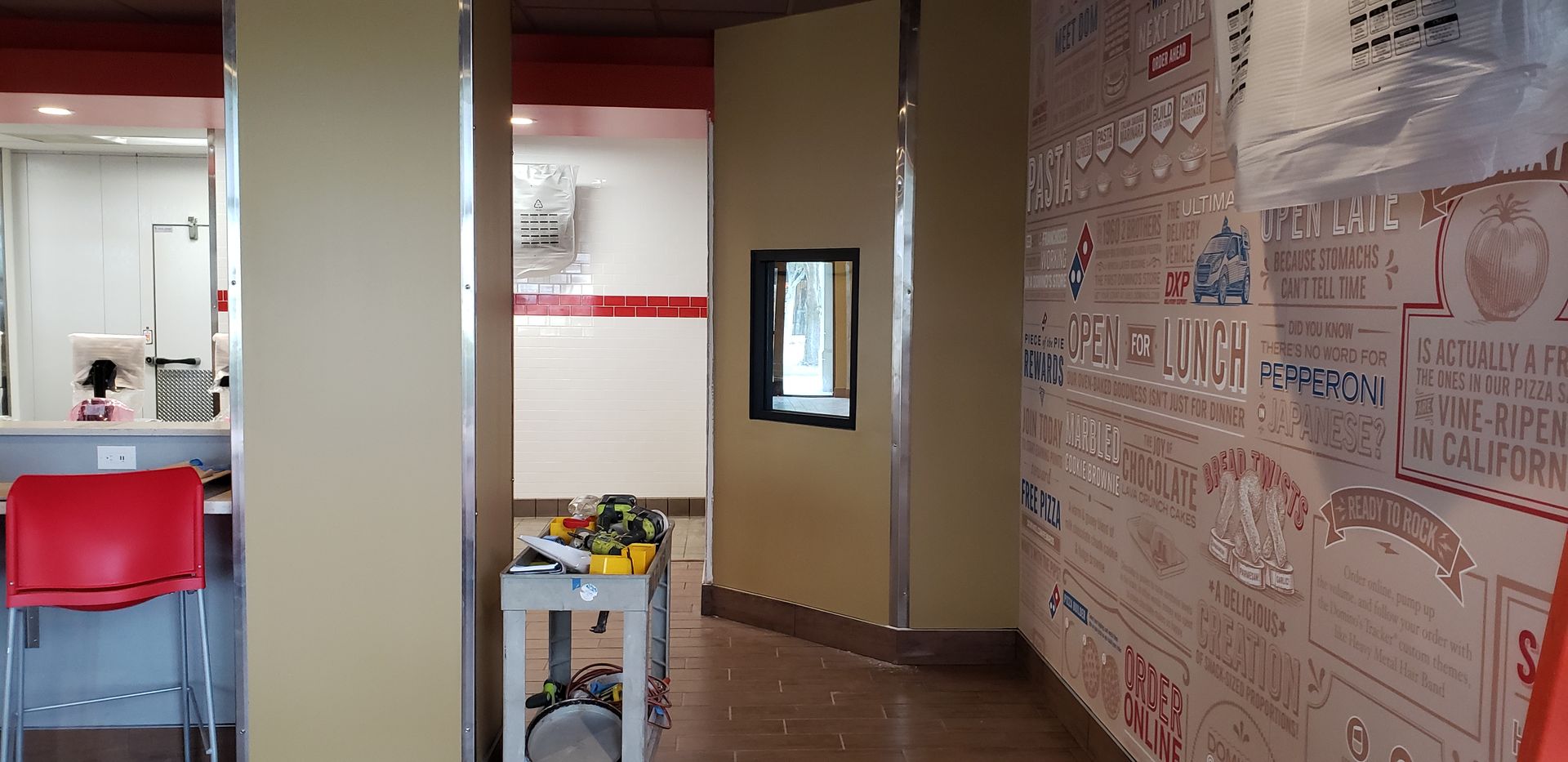 A hallway in a restaurant with a mural on the wall.