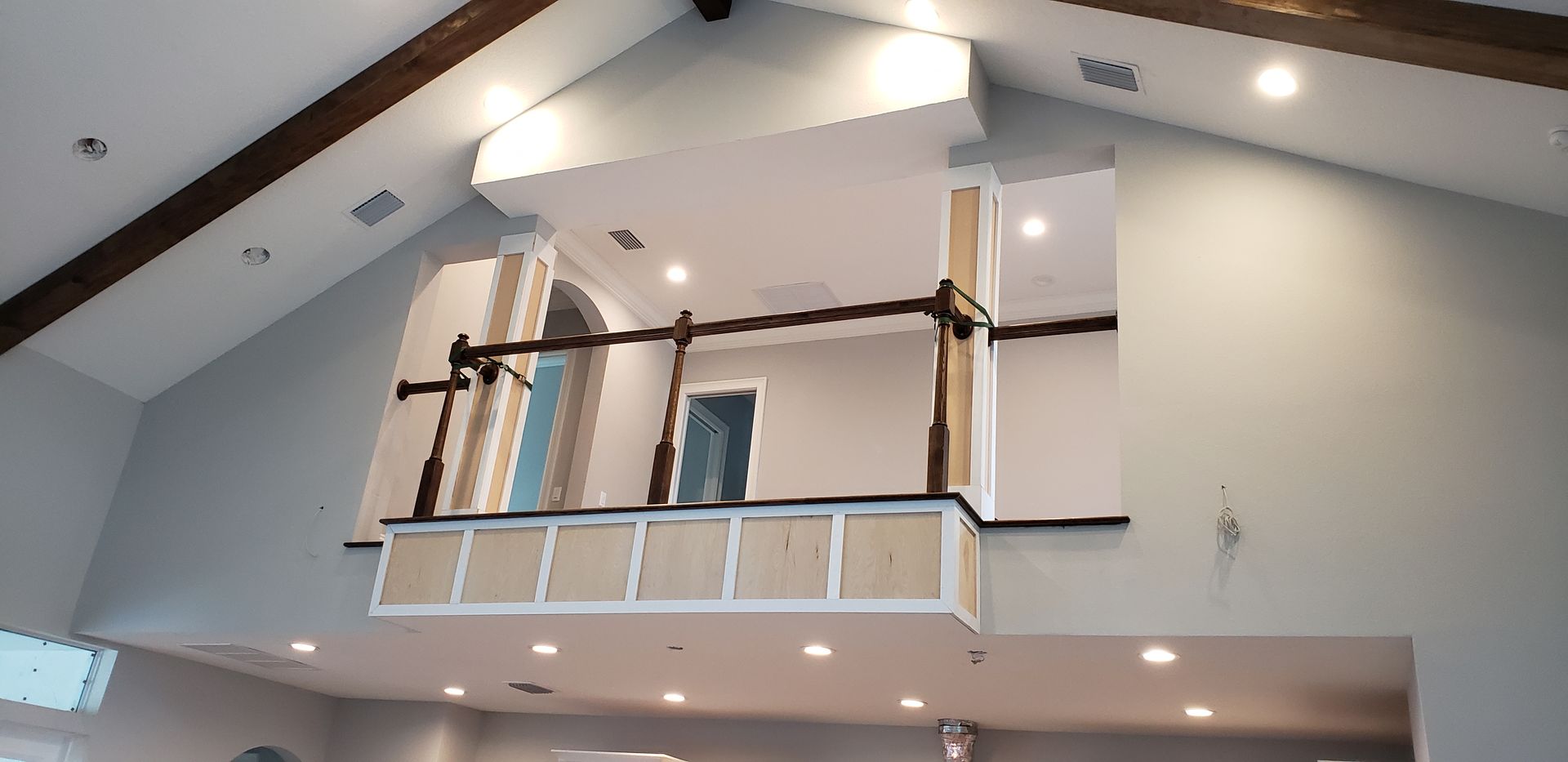 A large room with a vaulted ceiling and a balcony.