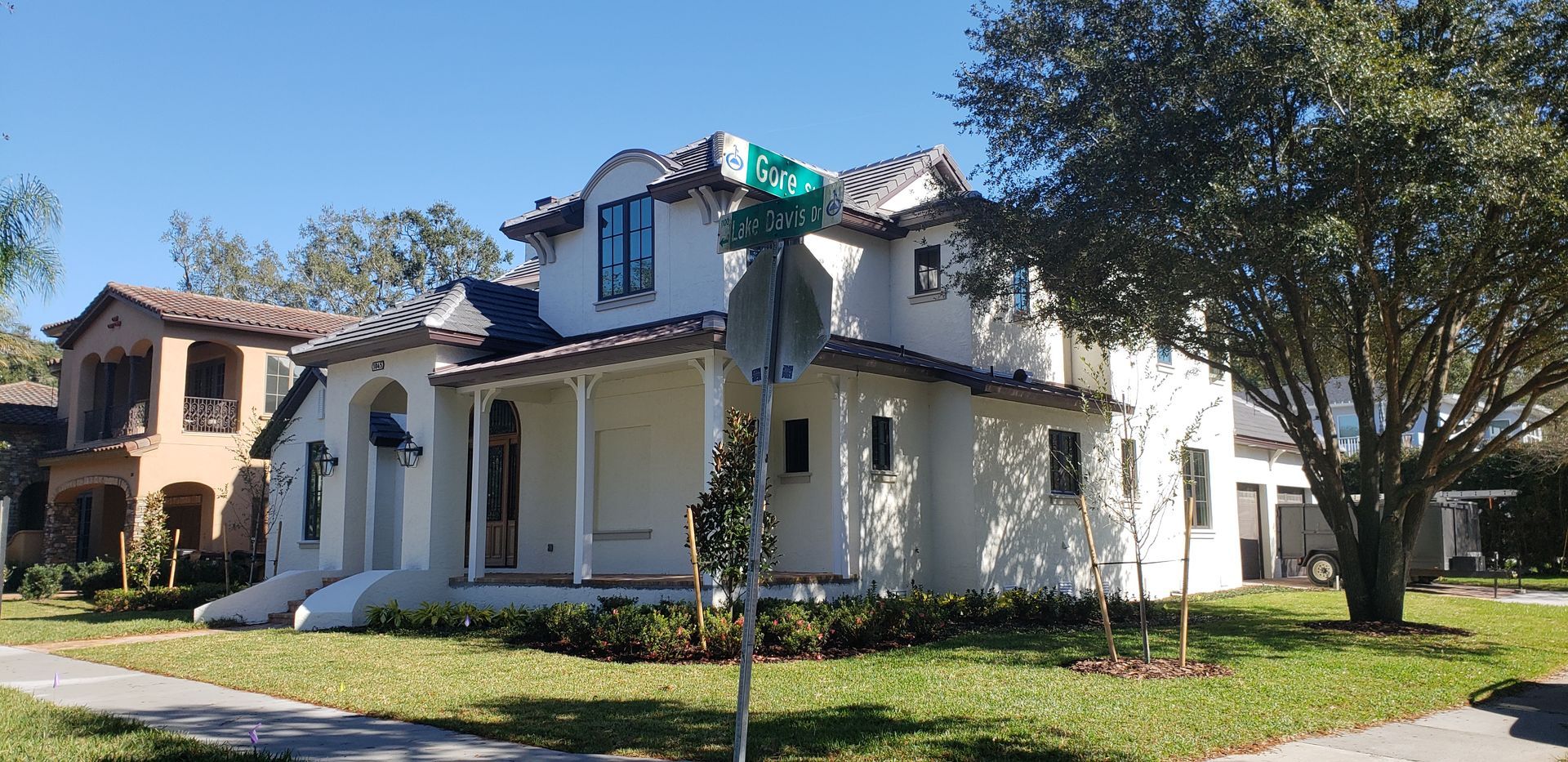 A white house with a green street sign in front of it